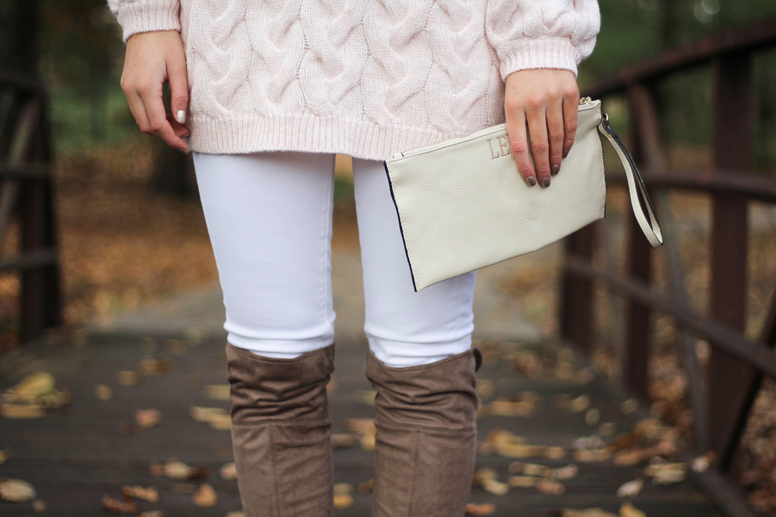 Pink cable knit sweater with white jeans and over the knee tan suede boots topped with an adorable faux fur beanie! The perfect winter outfit by Lauren Lindmark on dailydoseofcharm.com daily dose of charm