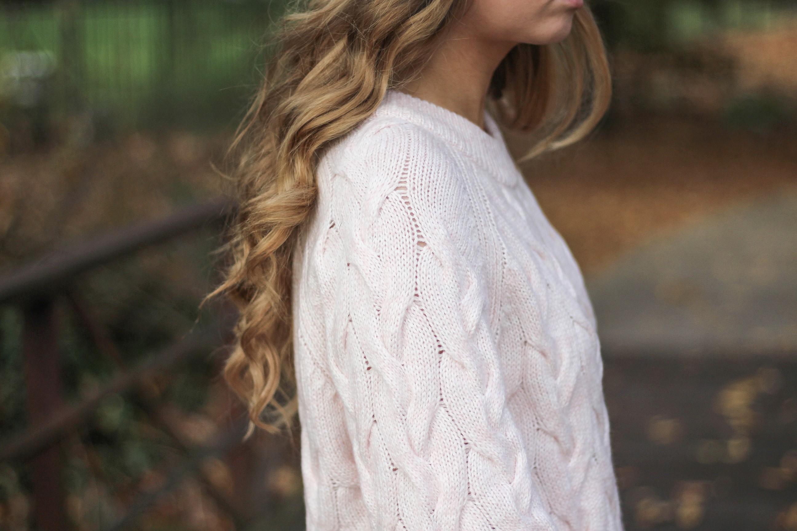 Pink cable knit sweater with white jeans and over the knee tan suede boots topped with an adorable faux fur beanie! The perfect winter outfit by Lauren Lindmark on dailydoseofcharm.com daily dose of charm