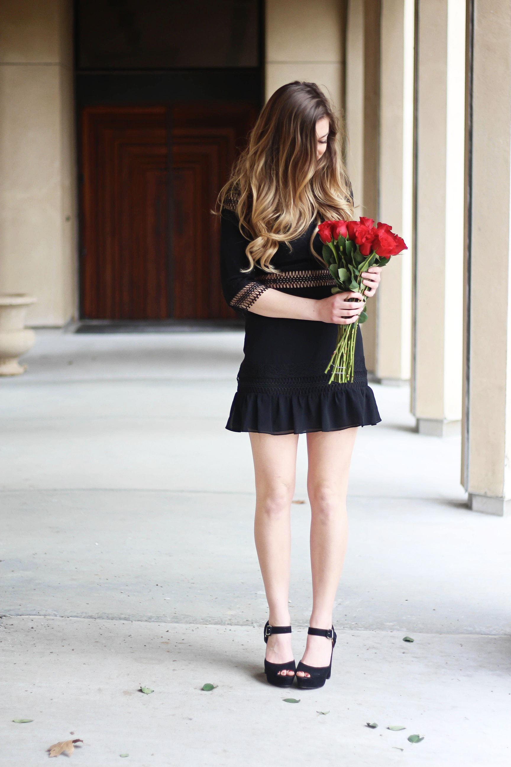 Valentines Day outfit! This little black dress is so perfect for any special occasion. I love the lace details around the waste and on the sleeves! I paired it with some chunky black heels, cluster earrings, and red lips! Plus of course some roses! By Lauren Lindmark on daily dose of charm dailydoseofcharm.com