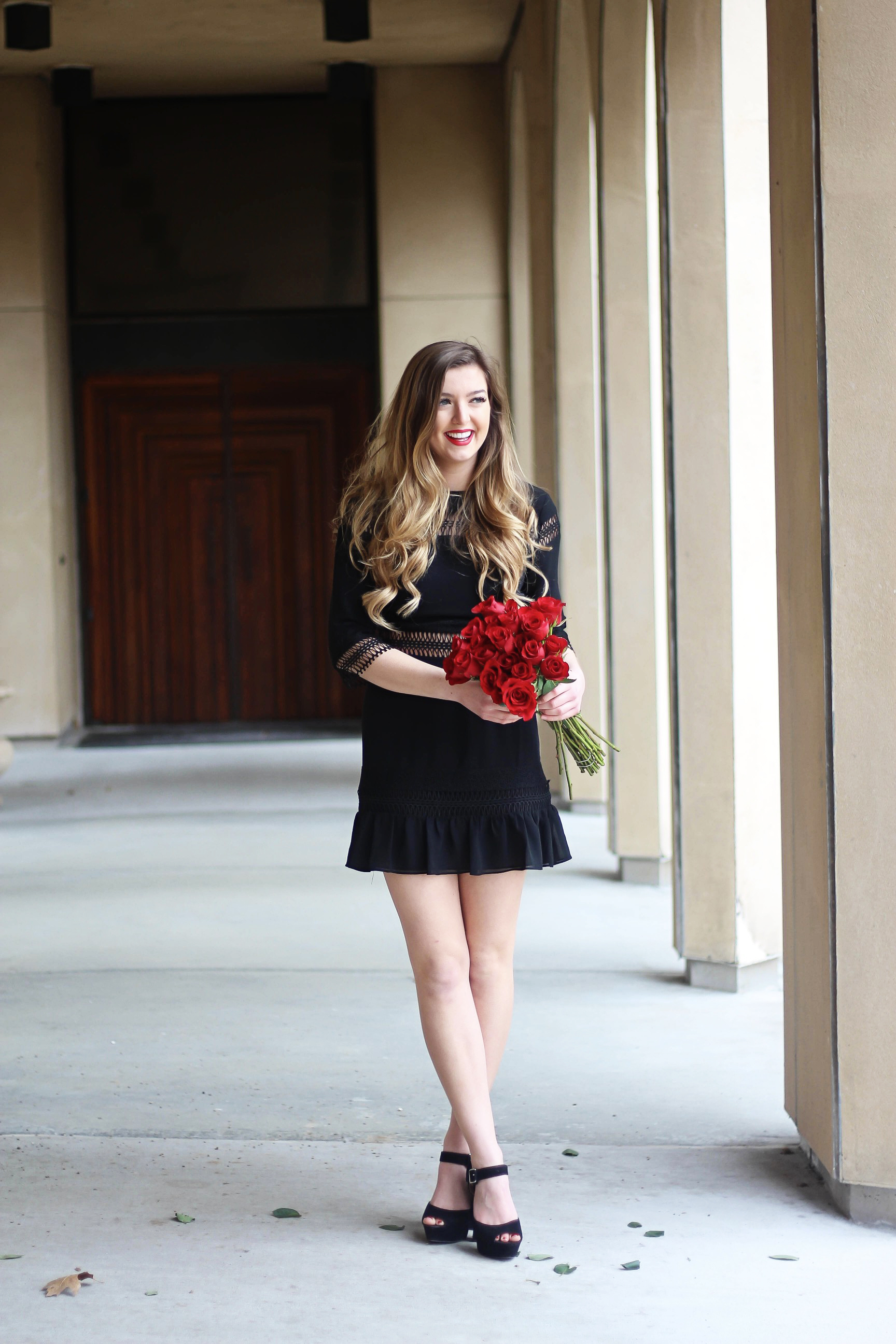 Valentines Day outfit! This little black dress is so perfect for any special occasion. I love the lace details around the waste and on the sleeves! I paired it with some chunky black heels, cluster earrings, and red lips! Plus of course some roses! By Lauren Lindmark on daily dose of charm dailydoseofcharm.com