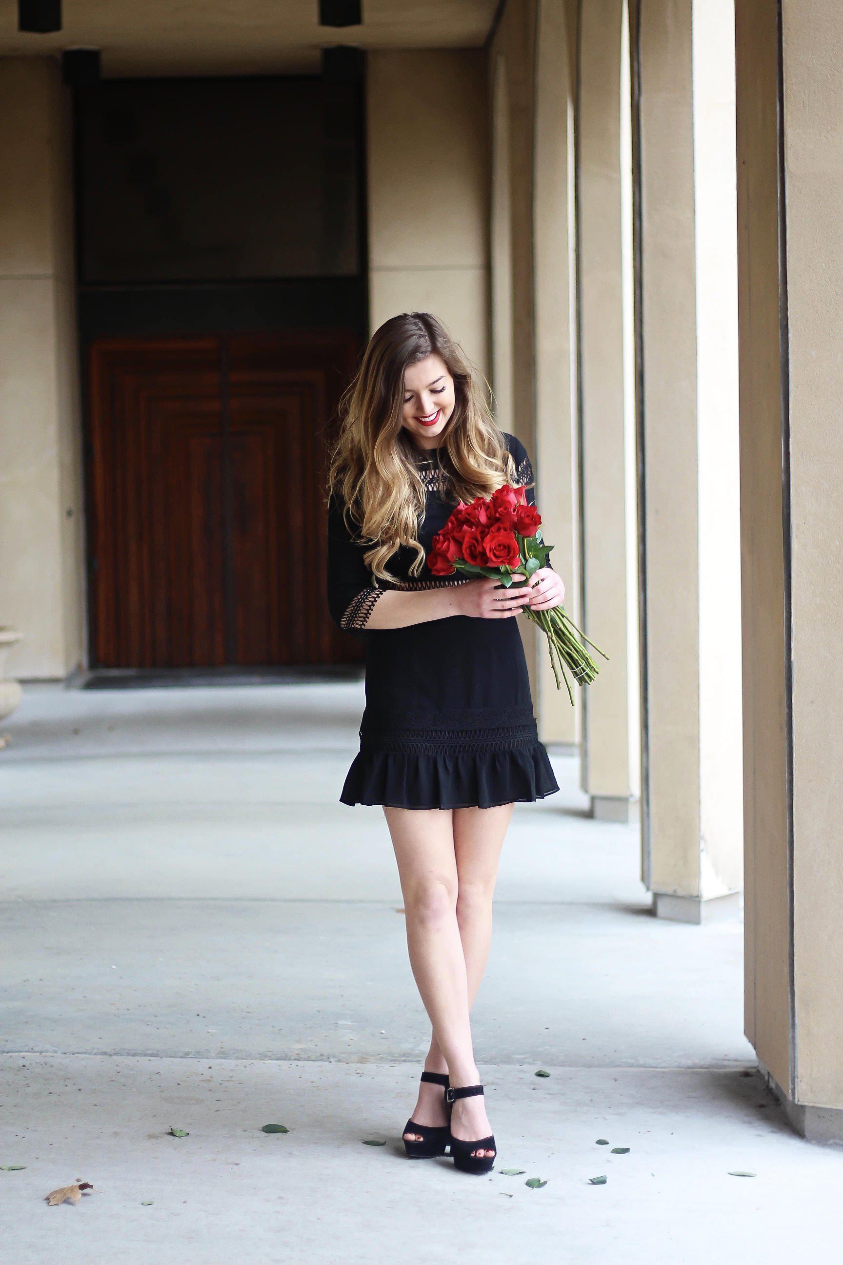 Valentines Day outfit! This little black dress is so perfect for any special occasion. I love the lace details around the waste and on the sleeves! I paired it with some chunky black heels, cluster earrings, and red lips! Plus of course some roses! By Lauren Lindmark on daily dose of charm dailydoseofcharm.com