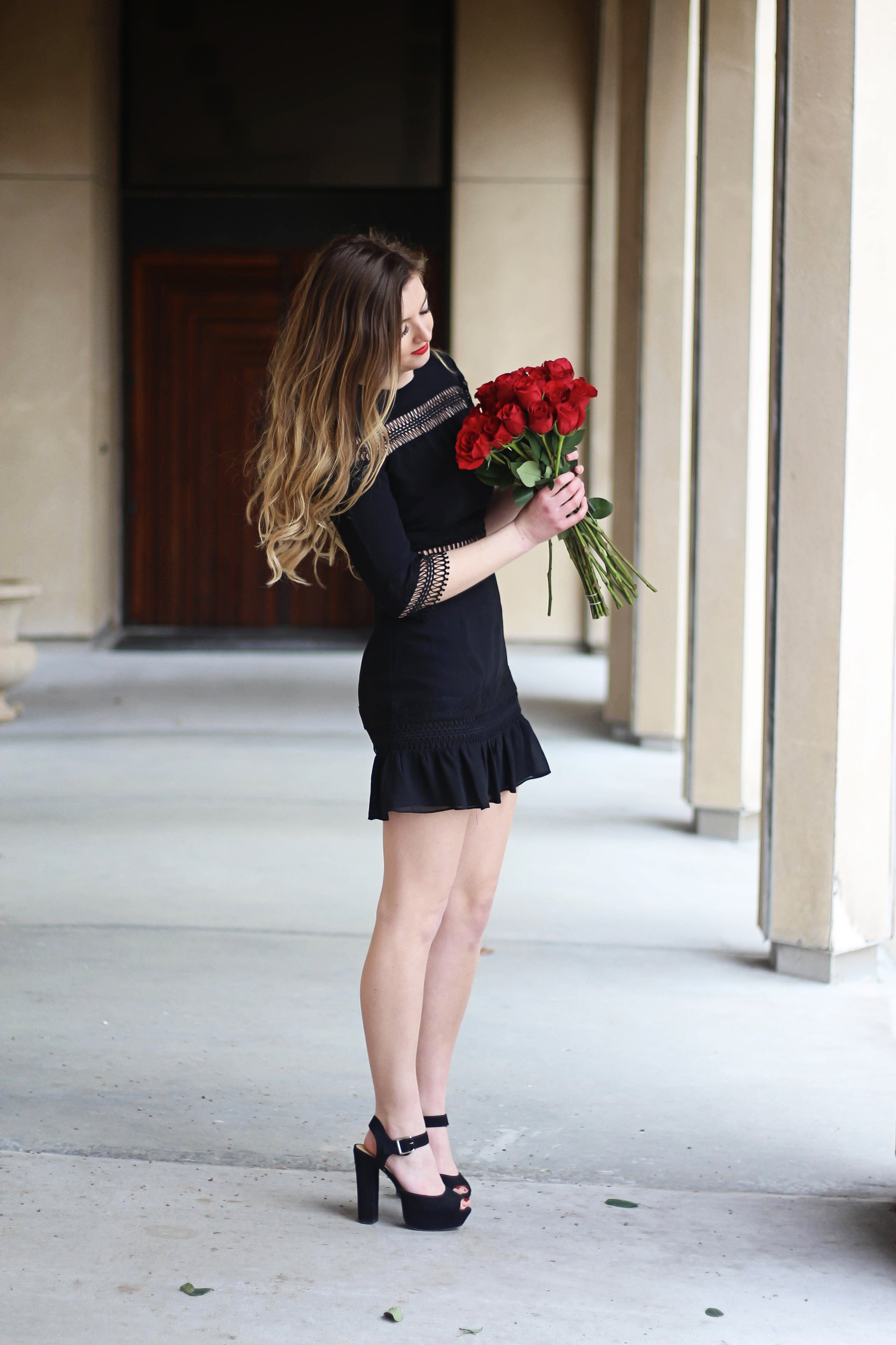 Valentines Day outfit! This little black dress is so perfect for any special occasion. I love the lace details around the waste and on the sleeves! I paired it with some chunky black heels, cluster earrings, and red lips! Plus of course some roses! By Lauren Lindmark on daily dose of charm dailydoseofcharm.com