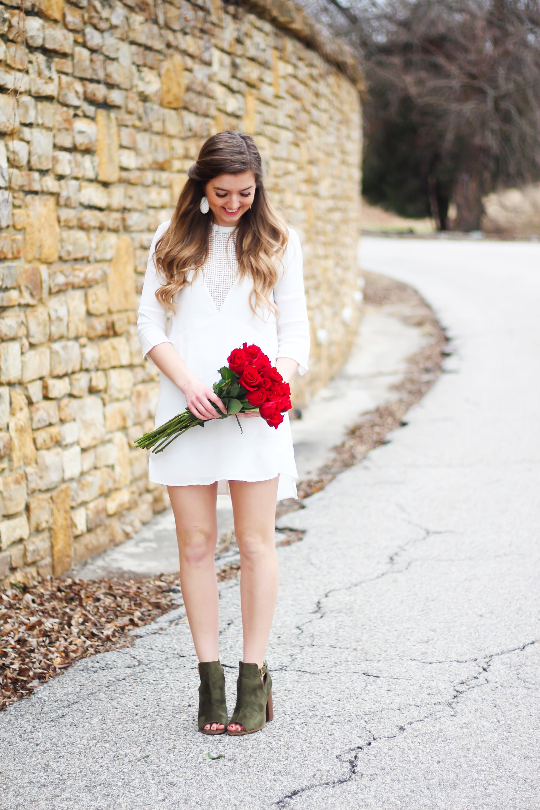 Perfect Valentine's Day look! If you need to know what to wear for Valentines Day look no further! Love this white deep vneck lace dress, especially with hunter green booties! I paired it with white Kendra Scott earrings and my ray ban aviators! By Lauren Lindmark daily dose of charm on dailydoseofcharm.com 