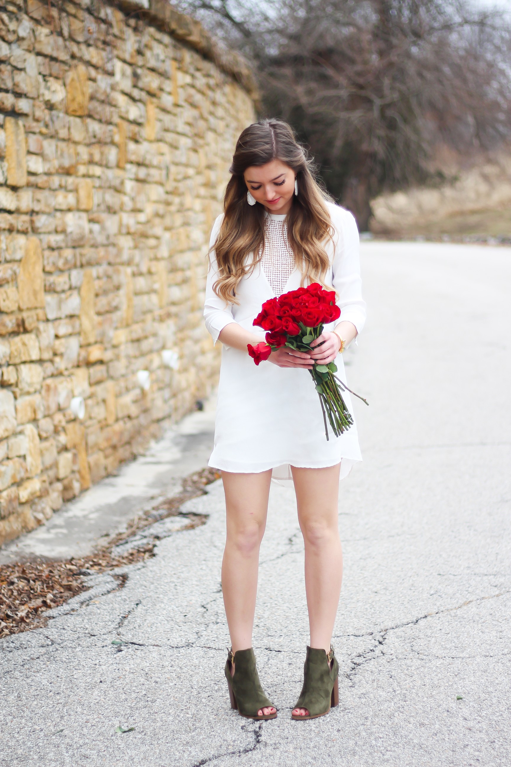 Perfect Valentine's Day look! If you need to know what to wear for Valentines Day look no further! Love this white deep vneck lace dress, especially with hunter green booties! I paired it with white Kendra Scott earrings and my ray ban aviators! By Lauren Lindmark daily dose of charm on dailydoseofcharm.com 