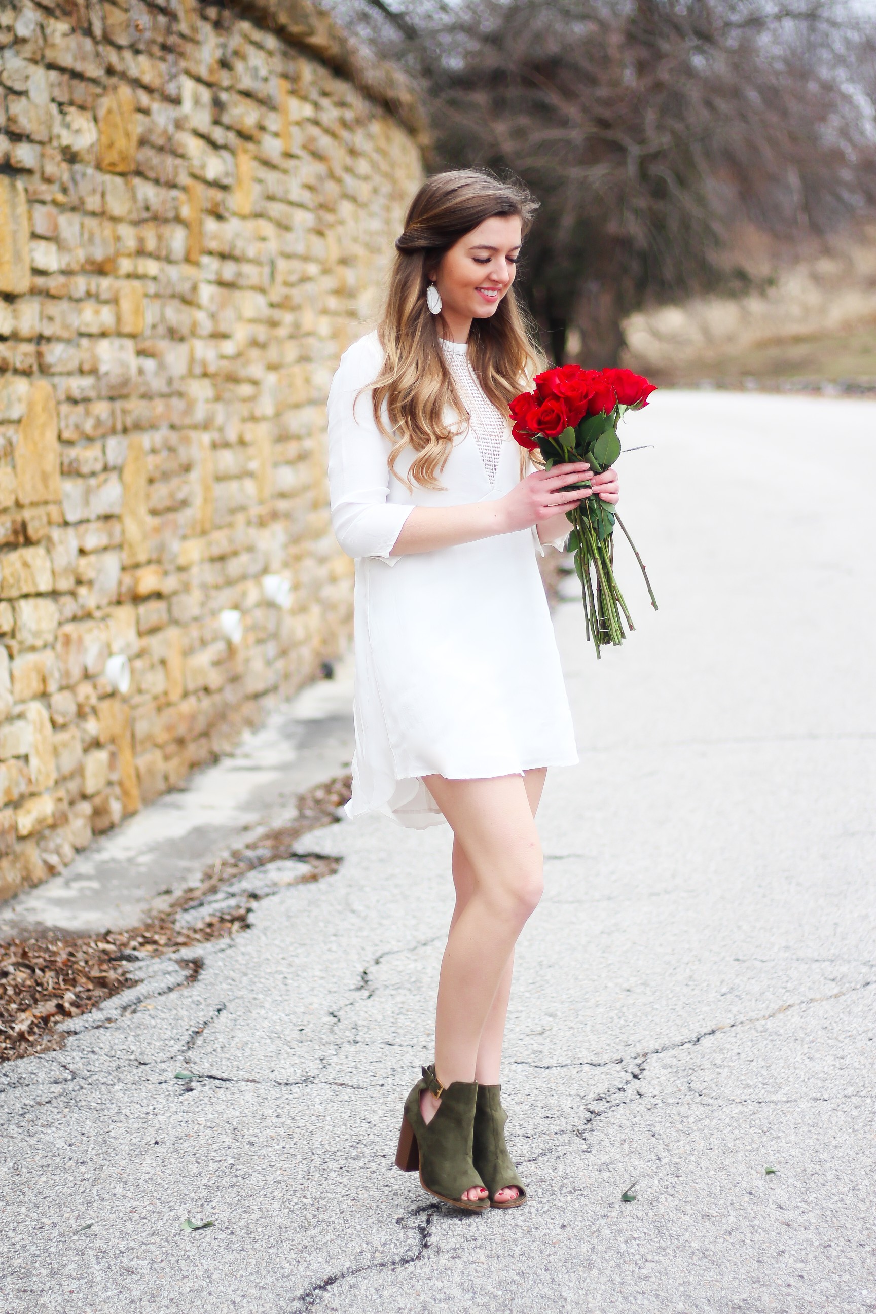 Perfect Valentine's Day look! If you need to know what to wear for Valentines Day look no further! Love this white deep vneck lace dress, especially with hunter green booties! I paired it with white Kendra Scott earrings and my ray ban aviators! By Lauren Lindmark daily dose of charm on dailydoseofcharm.com 