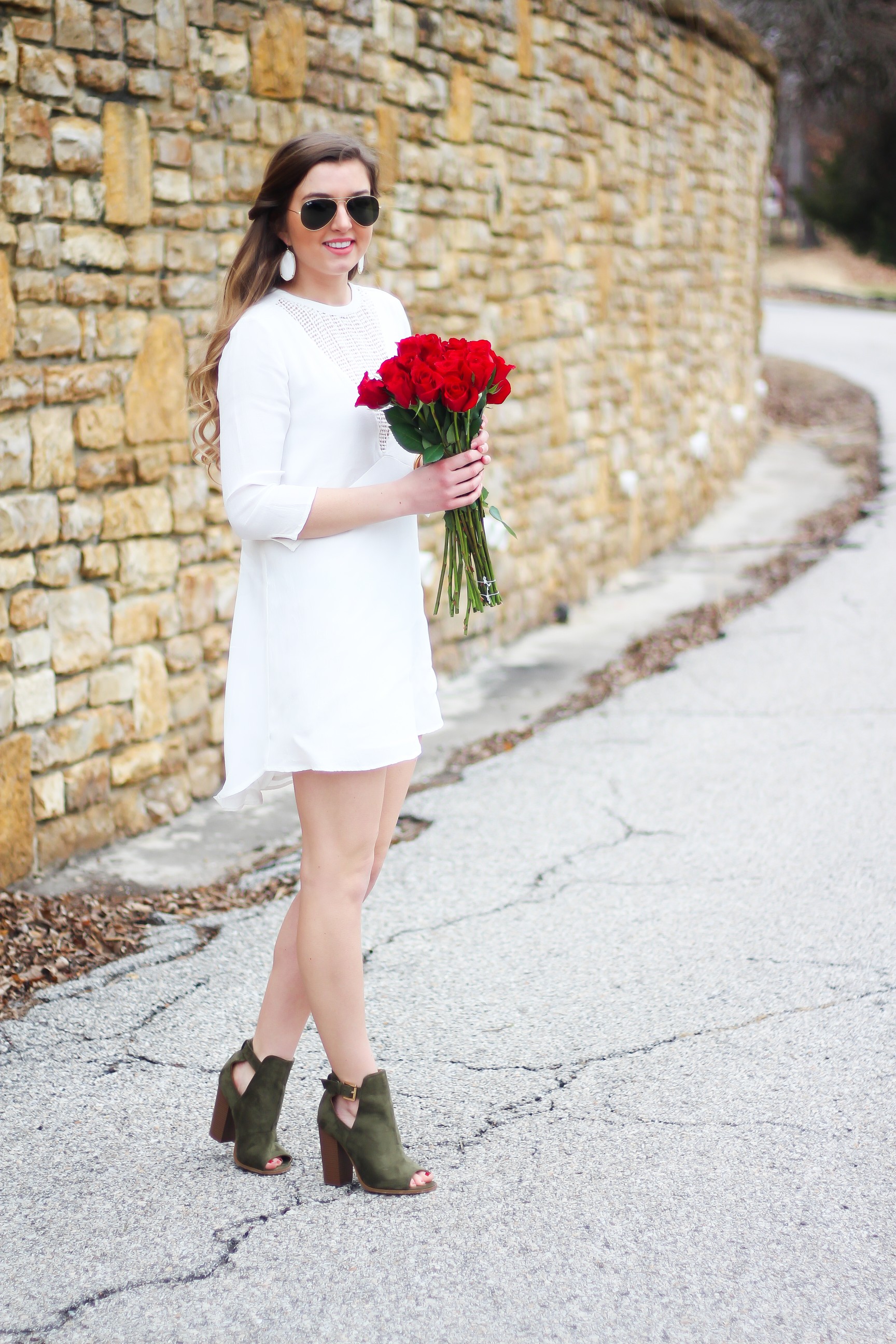 Perfect Valentine's Day look! If you need to know what to wear for Valentines Day look no further! Love this white deep vneck lace dress, especially with hunter green booties! I paired it with white Kendra Scott earrings and my ray ban aviators! By Lauren Lindmark daily dose of charm on dailydoseofcharm.com 