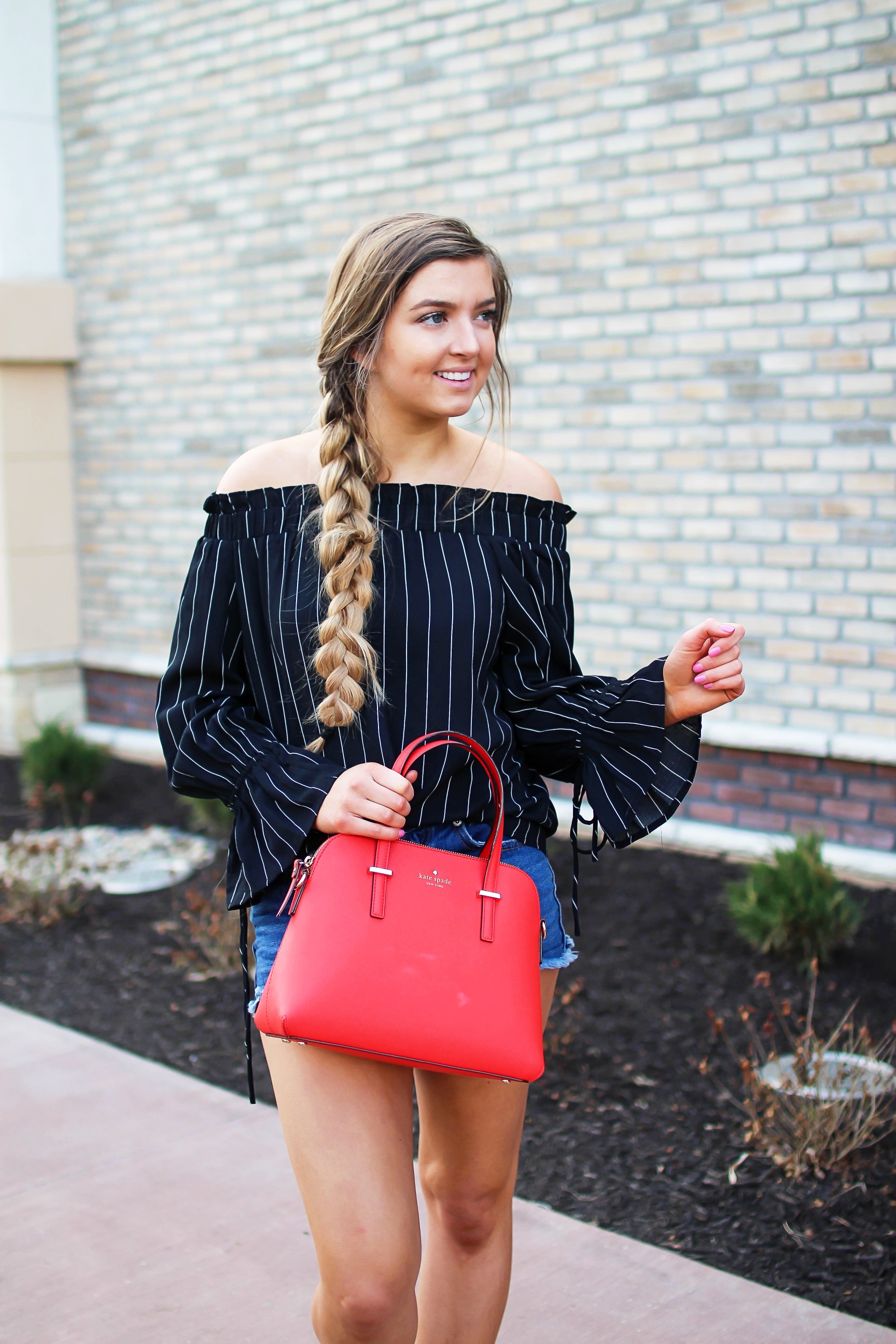 The cutest black striped off the shoulder top paired with jean shorts and a red Kate Spade purse. My favorite tassel shoes go perfectly with this look! I finished off the look with my long hair in a side braid. I love this outfit idea! By Lauren Lindmark on daily dose of charm dailydoseofcharm.com