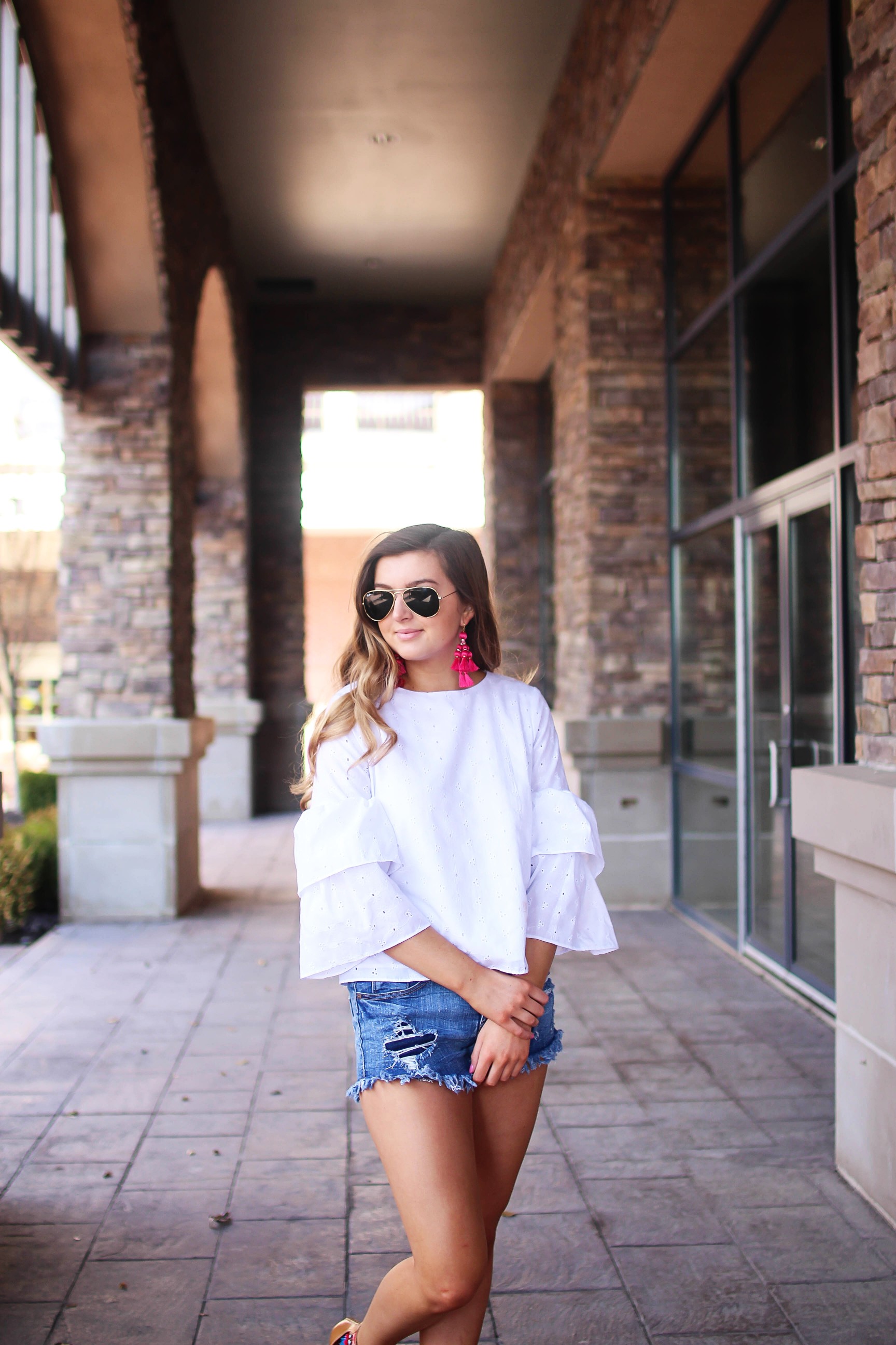 The cutest fiesta top ever! The ruffle sleeves on the top are so unique and such a cute outfit idea! I paired it with ripped jeans shorts and my tassel sandals and Kate Spade tassel earrings! By Lauren Lindmark on dailydoseofcharm.com daily dose of charm