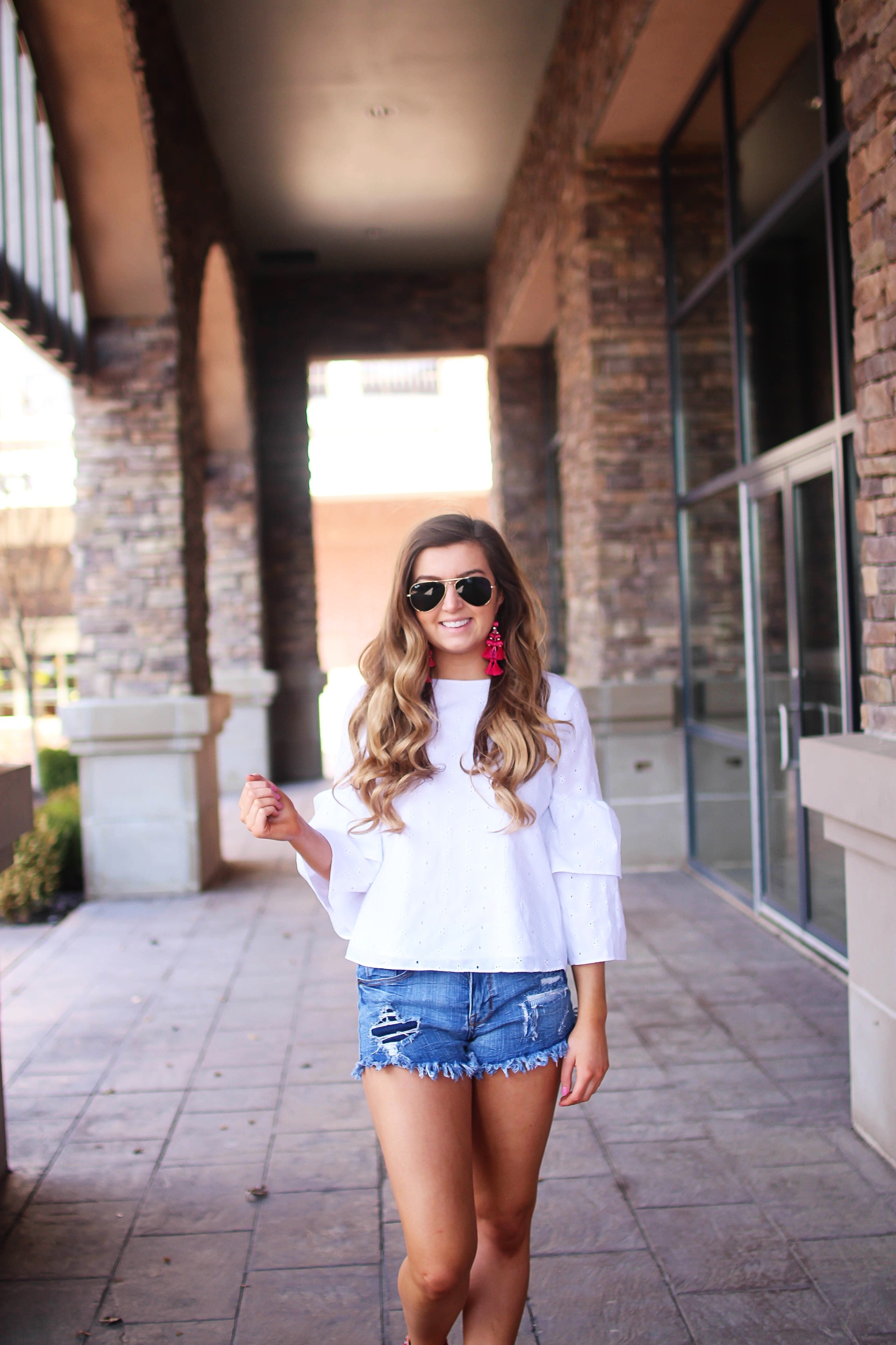 The cutest fiesta top ever! The ruffle sleeves on the top are so unique and such a cute outfit idea! I paired it with ripped jeans shorts and my tassel sandals and Kate Spade tassel earrings! By Lauren Lindmark on dailydoseofcharm.com daily dose of charm