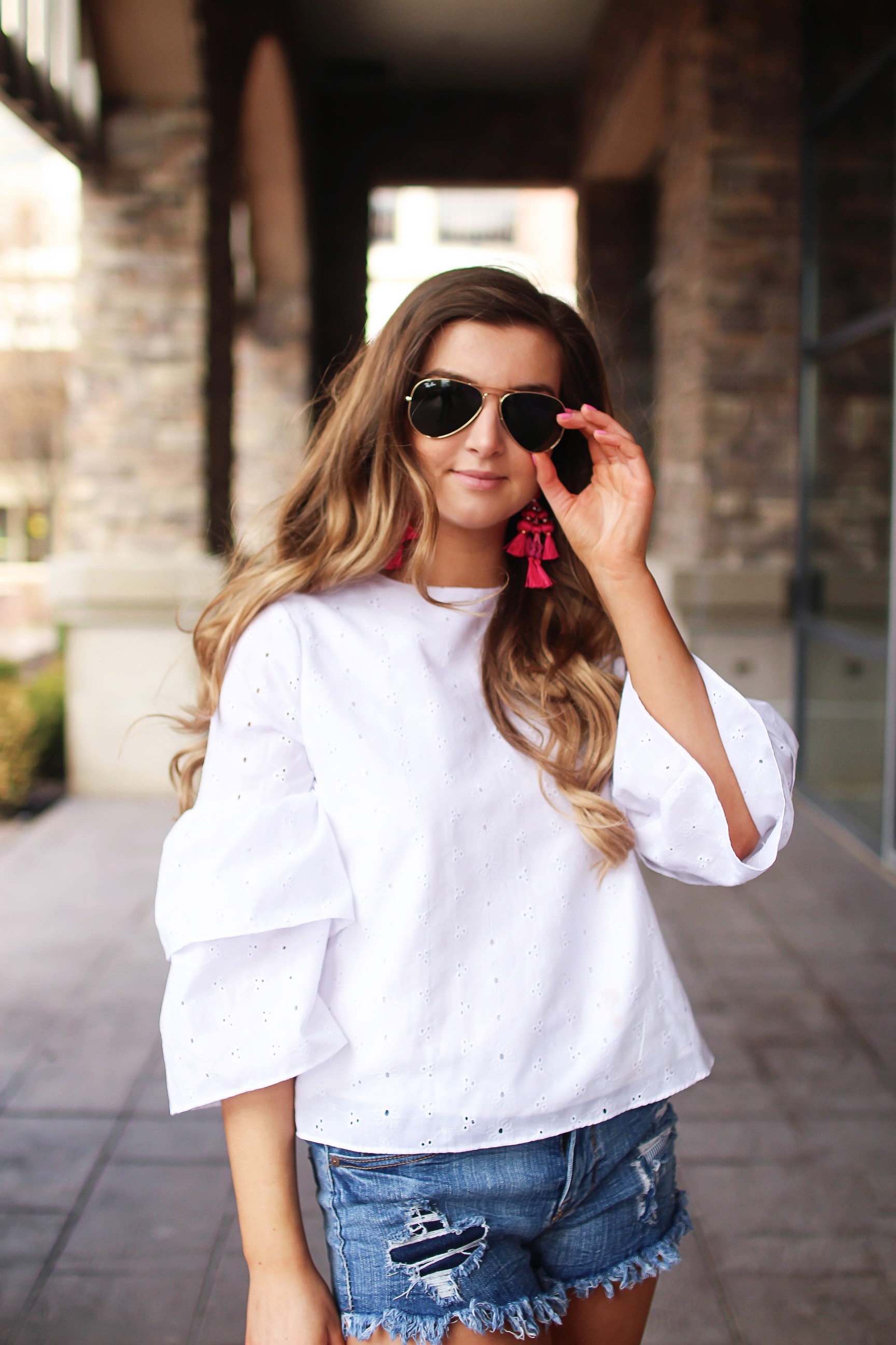 The cutest fiesta top ever! The ruffle sleeves on the top are so unique and such a cute outfit idea! I paired it with ripped jeans shorts and my tassel sandals and Kate Spade tassel earrings! By Lauren Lindmark on dailydoseofcharm.com daily dose of charm