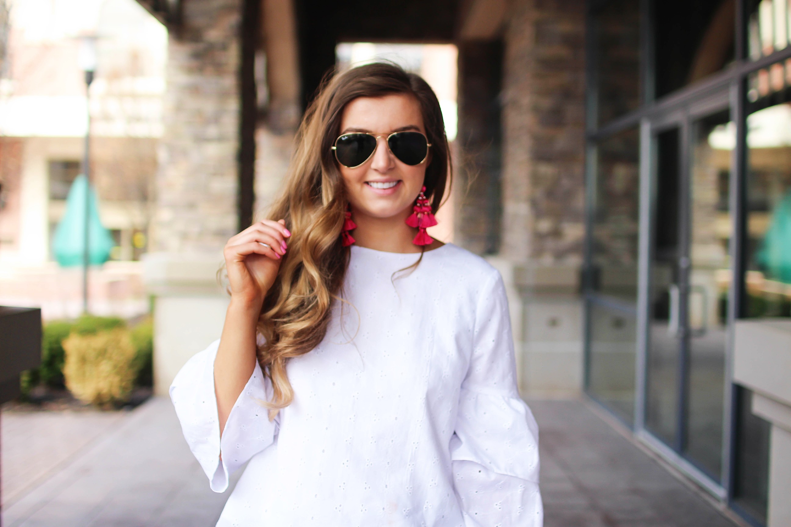 The cutest fiesta top ever! The ruffle sleeves on the top are so unique and such a cute outfit idea! I paired it with ripped jeans shorts and my tassel sandals and Kate Spade tassel earrings! By Lauren Lindmark on dailydoseofcharm.com daily dose of charm