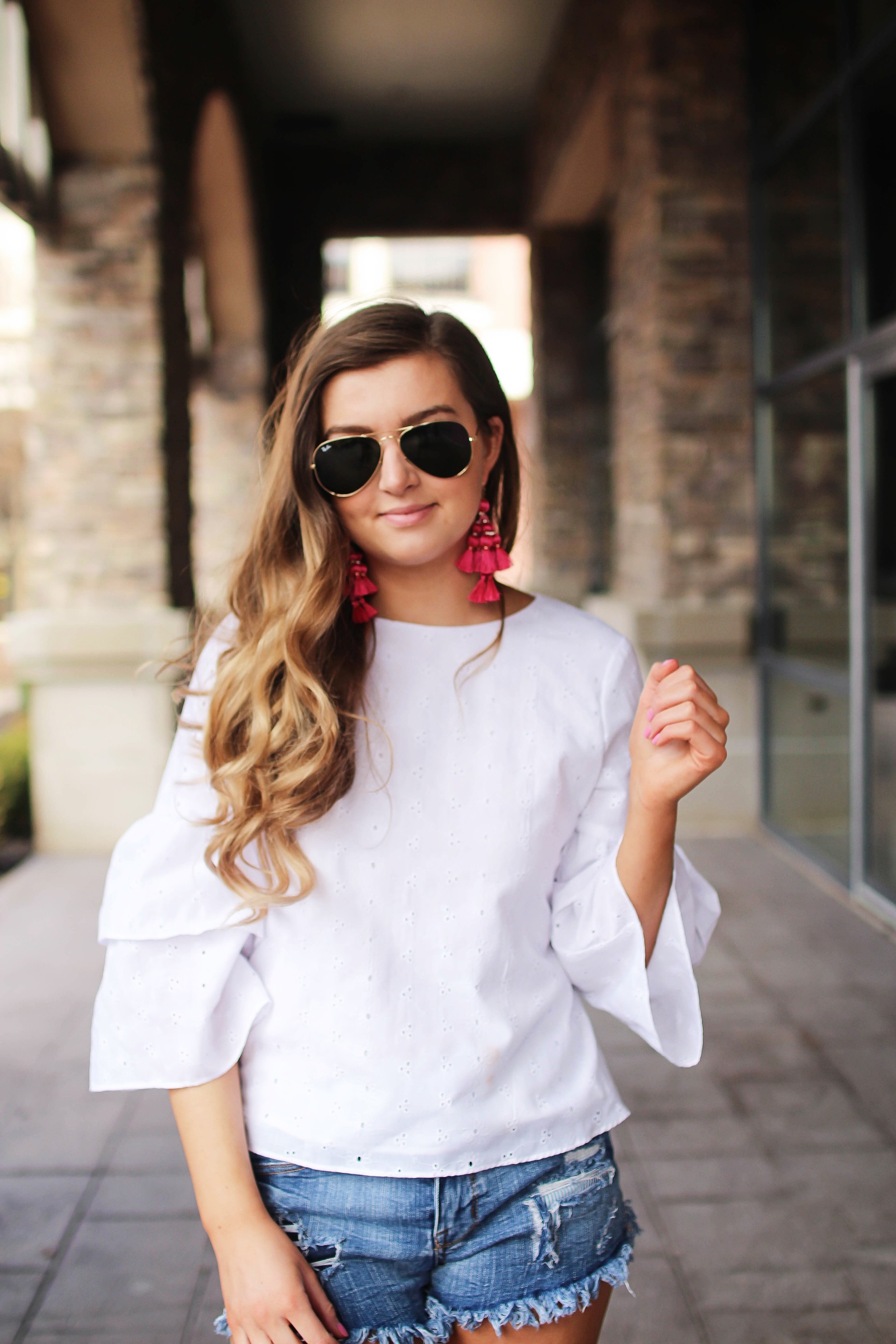 The cutest fiesta top ever! The ruffle sleeves on the top are so unique and such a cute outfit idea! I paired it with ripped jeans shorts and my tassel sandals and Kate Spade tassel earrings! By Lauren Lindmark on dailydoseofcharm.com daily dose of charm