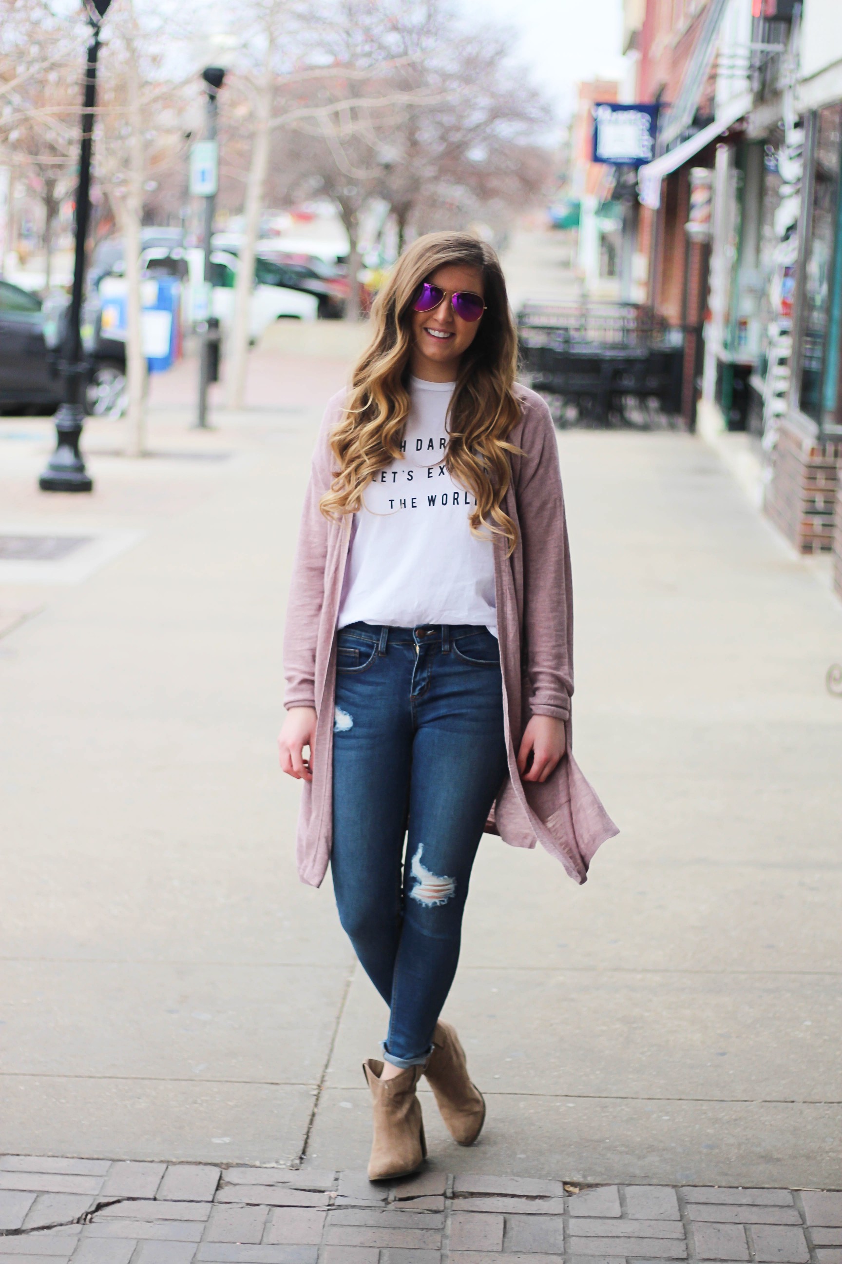 The cutest purple/pink cardigan for spring paired with my Oh Darling Let's Explore the World tee! I love this tee because it matches my wanderlust! I paired it with my favorite ripped jeans and tan suede booties. Plus of course my pink ray bans! By Lauren Lindmark on Daily Dose of Charm