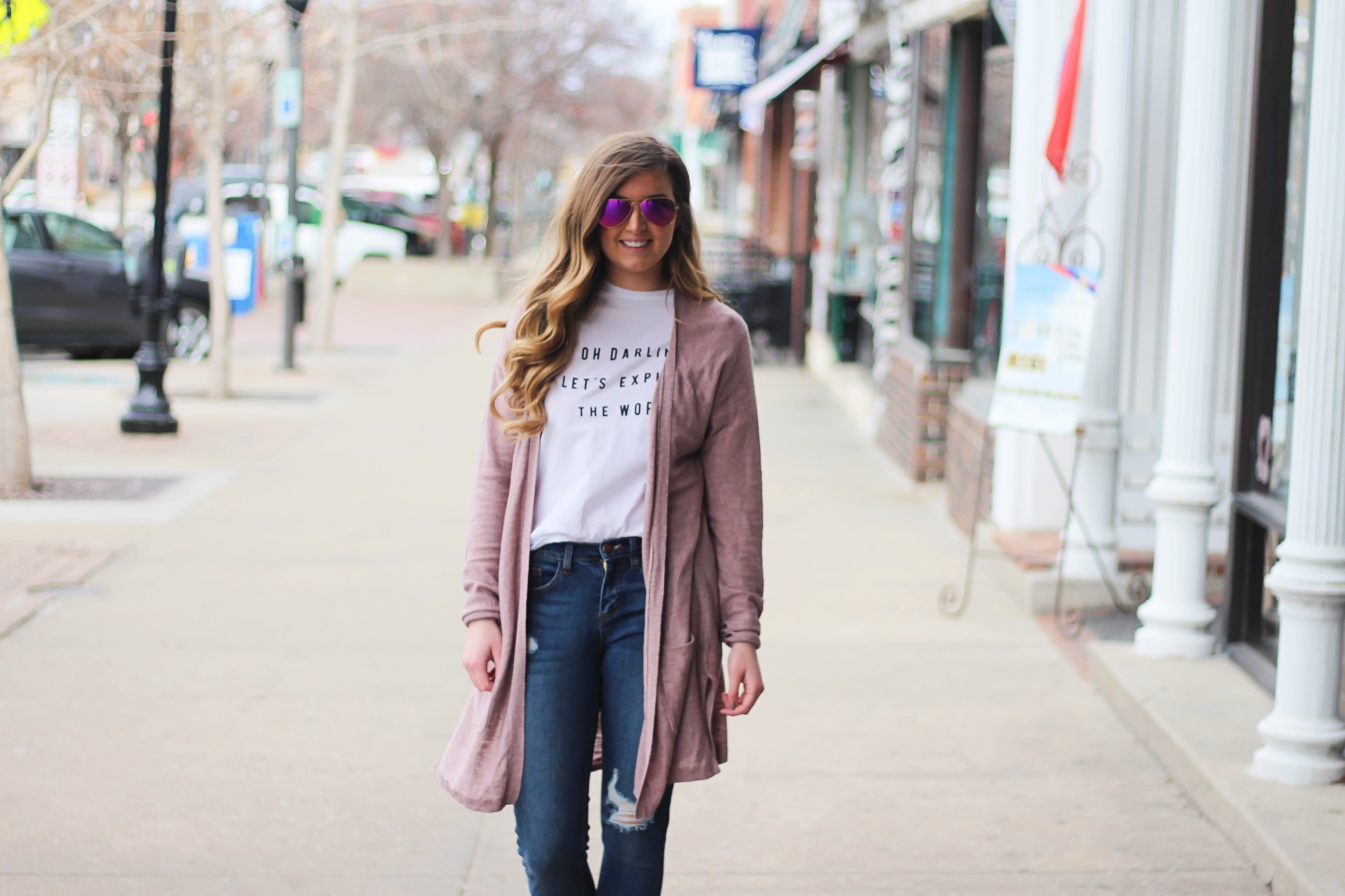 The cutest purple/pink cardigan for spring paired with my Oh Darling Let's Explore the World tee! I love this tee because it matches my wanderlust! I paired it with my favorite ripped jeans and tan suede booties. Plus of course my pink ray bans! By Lauren Lindmark on Daily Dose of Charm