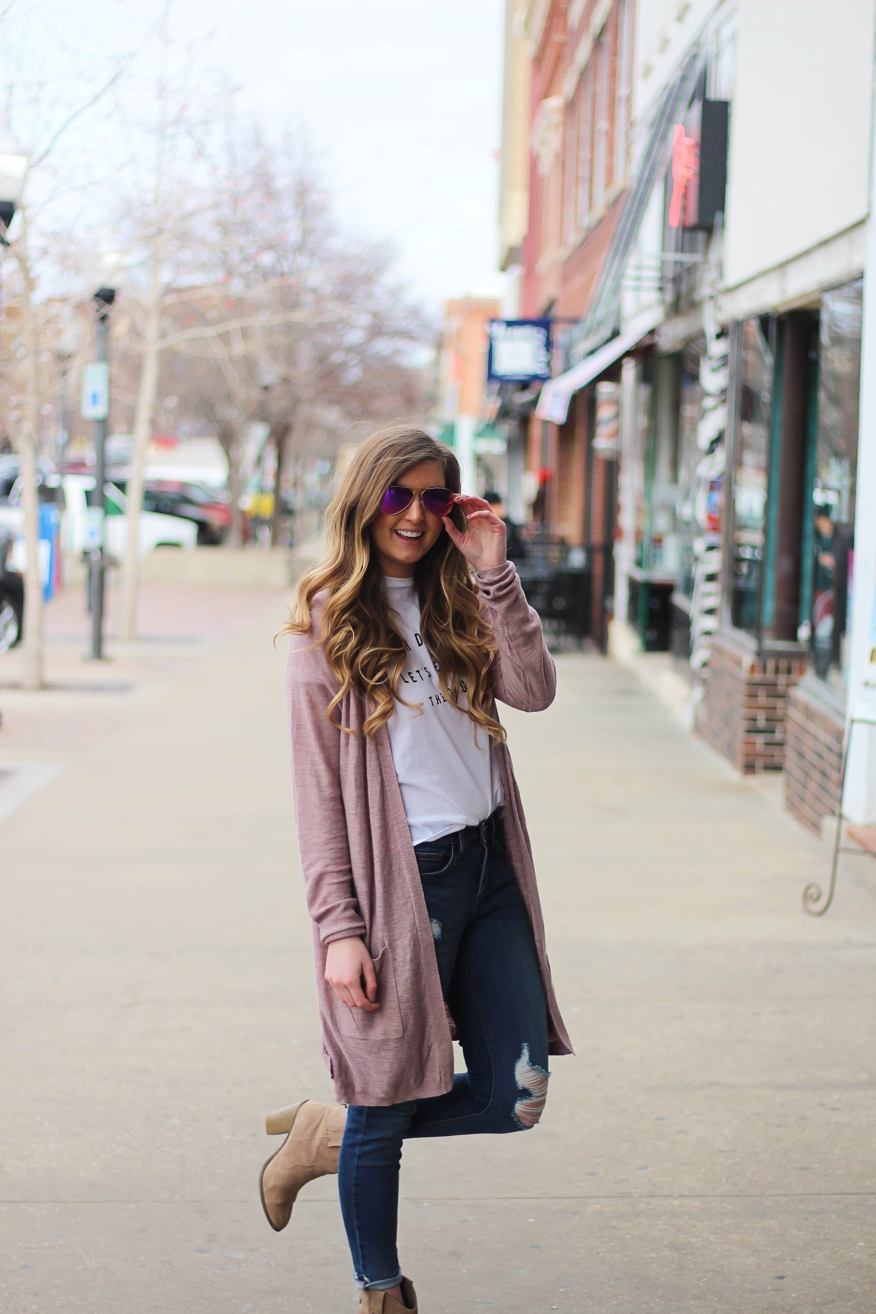 The cutest purple/pink cardigan for spring paired with my Oh Darling Let's Explore the World tee! I love this tee because it matches my wanderlust! I paired it with my favorite ripped jeans and tan suede booties. Plus of course my pink ray bans! By Lauren Lindmark on Daily Dose of Charm