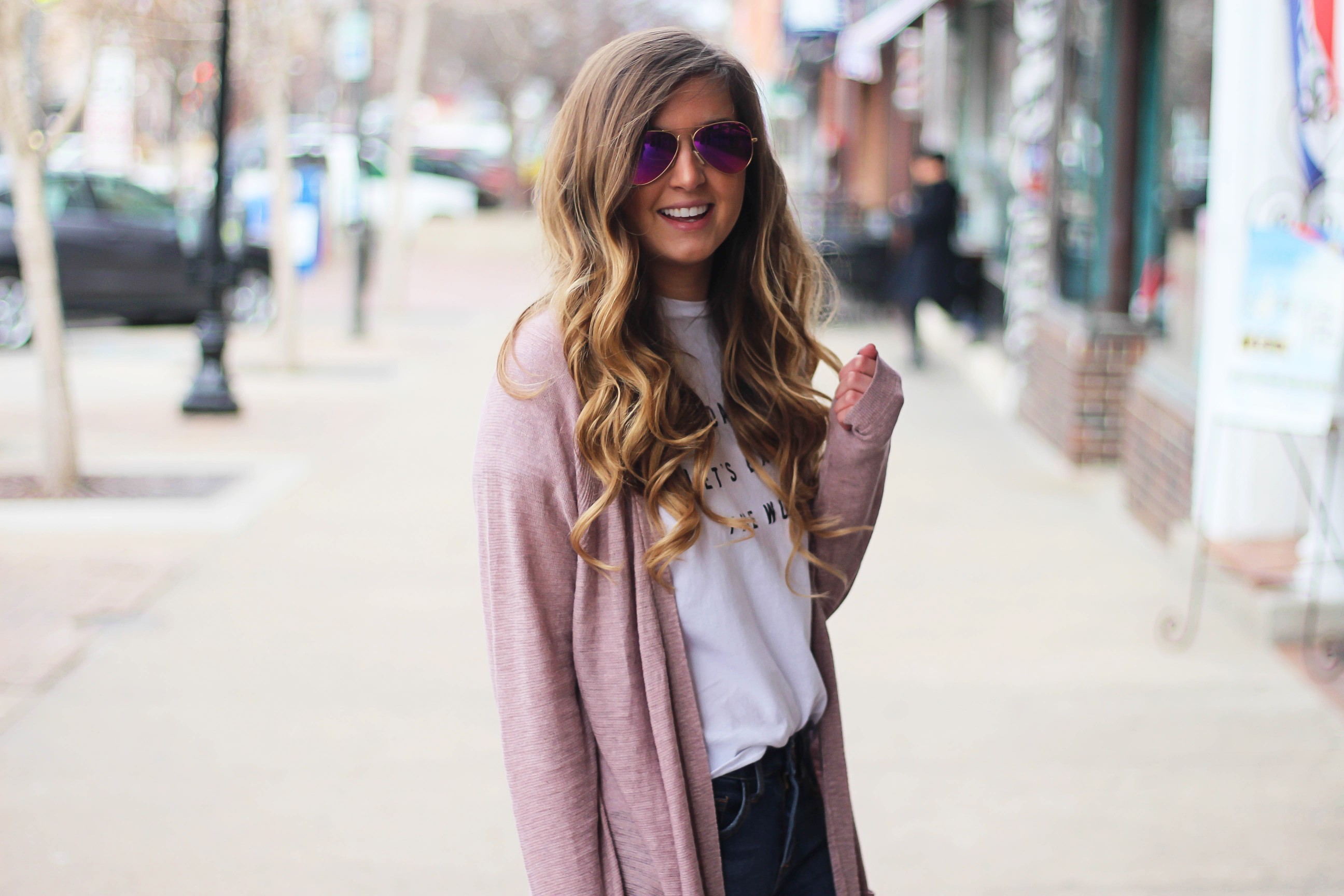 The cutest purple/pink cardigan for spring paired with my Oh Darling Let's Explore the World tee! I love this tee because it matches my wanderlust! I paired it with my favorite ripped jeans and tan suede booties. Plus of course my pink ray bans! By Lauren Lindmark on Daily Dose of Charm