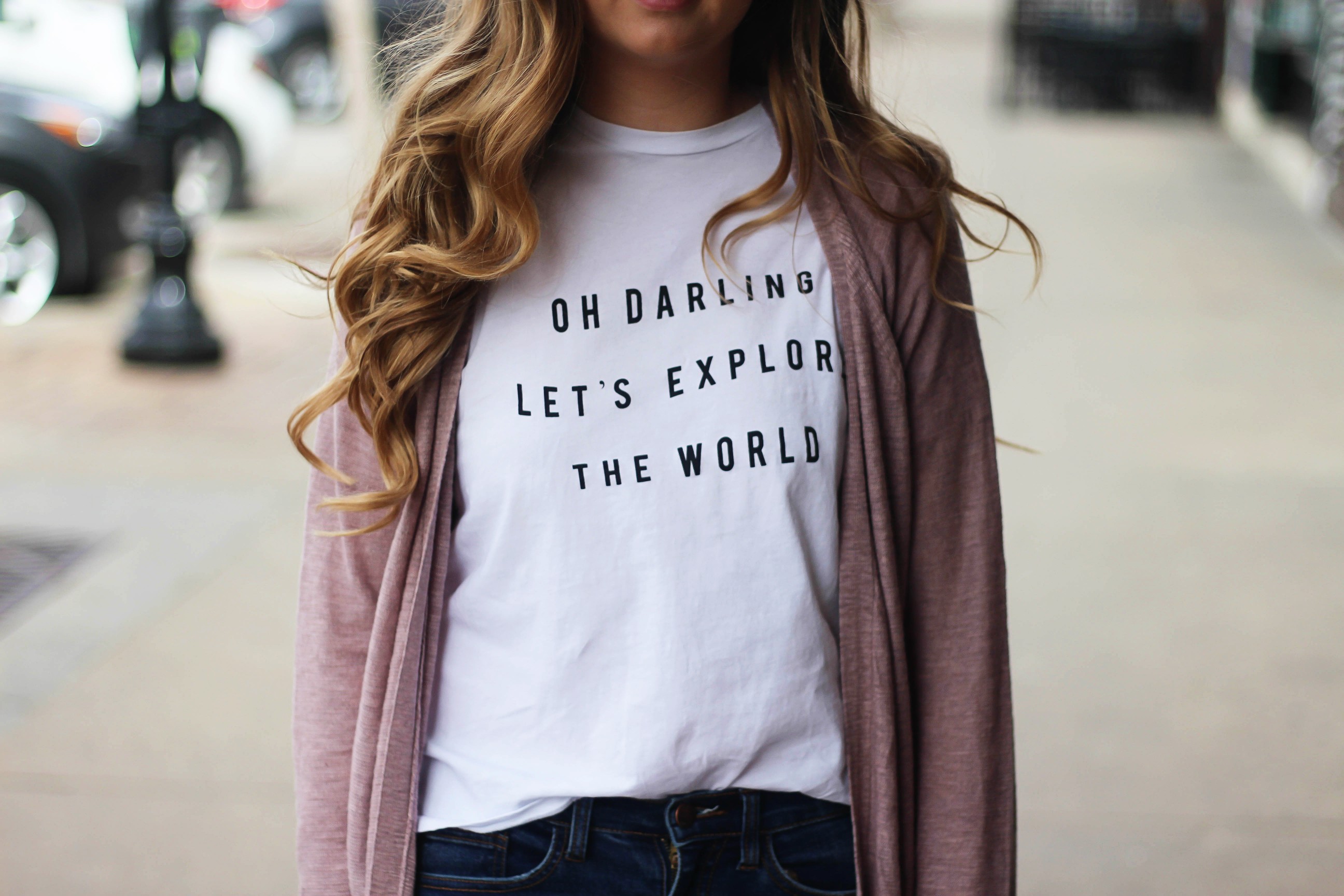 The cutest purple/pink cardigan for spring paired with my Oh Darling Let's Explore the World tee! I love this tee because it matches my wanderlust! I paired it with my favorite ripped jeans and tan suede booties. Plus of course my pink ray bans! By Lauren Lindmark on Daily Dose of Charm