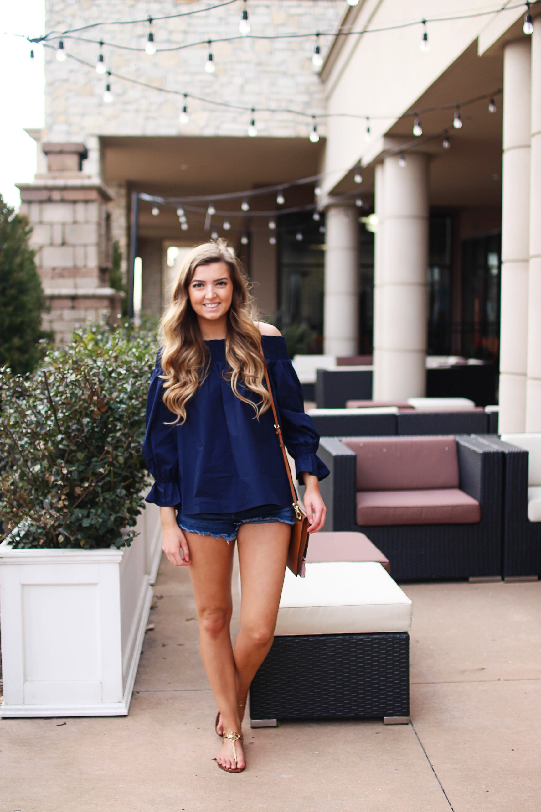 The cutest and most unique off the shoulder top you'll ever find! I love the bow on the back of the off the shoulder top and the unique sleeves. I paired it with the cutest tassel clutch and Tory Burch sandals! By Lauren Lindmark on daily dose of charm dailydoseofcharm.com