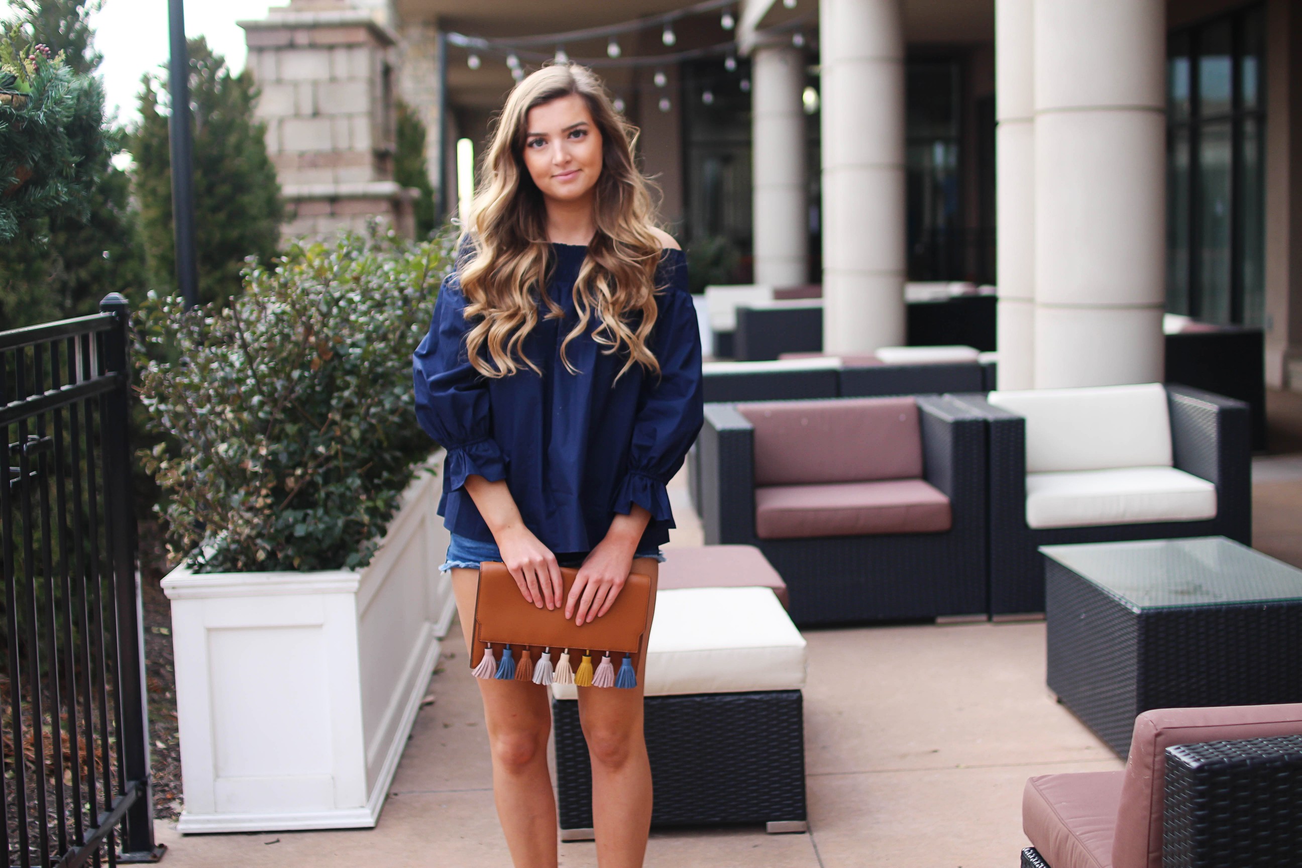 The cutest and most unique off the shoulder top you'll ever find! I love the bow on the back of the off the shoulder top and the unique sleeves. I paired it with the cutest tassel clutch and Tory Burch sandals! By Lauren Lindmark on daily dose of charm dailydoseofcharm.com