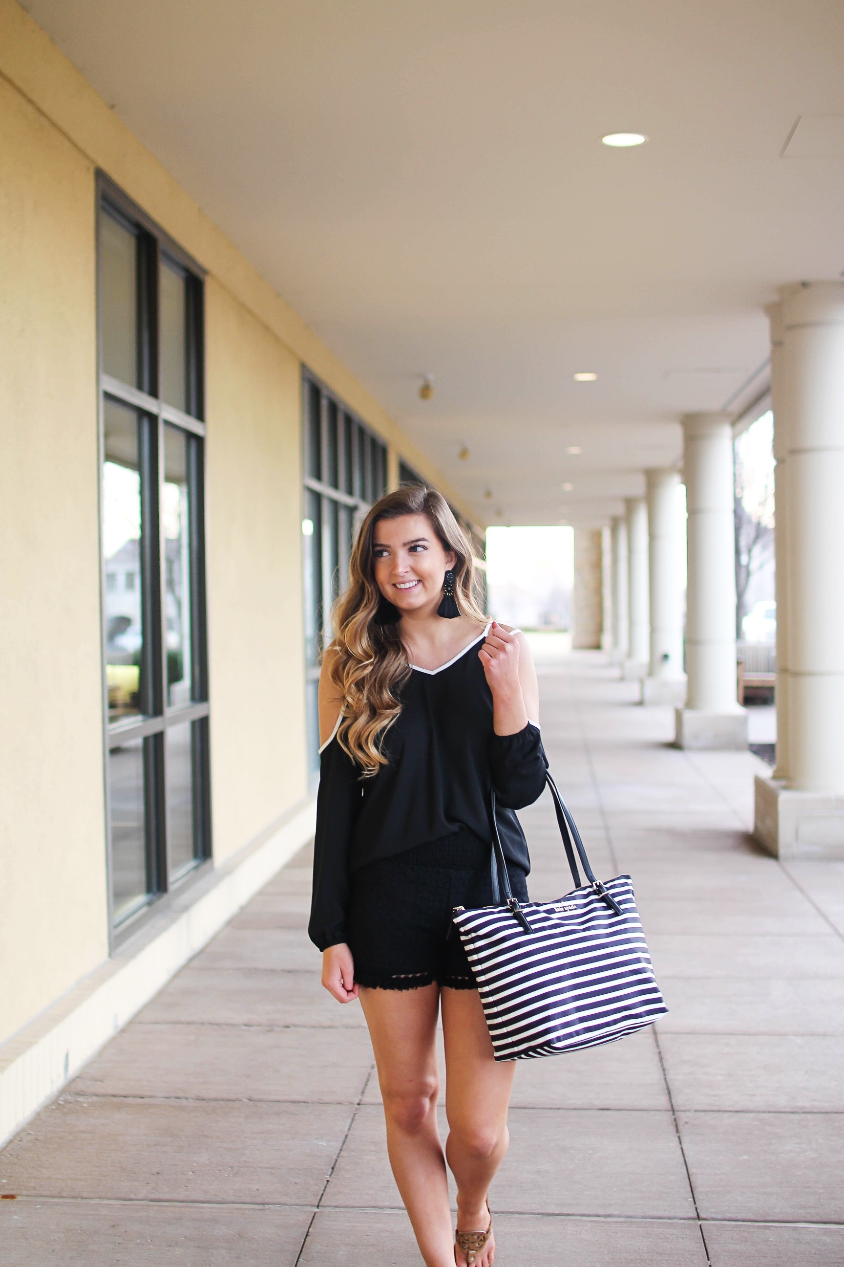 Black and white outfit! I love this black cold shoulder top with the white trim detail! I paired ti with some comfy black cotton shorts and my new black and white striped Kate spade tote! To finish off the outfit I put on my tassel earrings that are only $12! By Lauren Lindmark on Daily Dose of Charm dailydoseofcharm.com