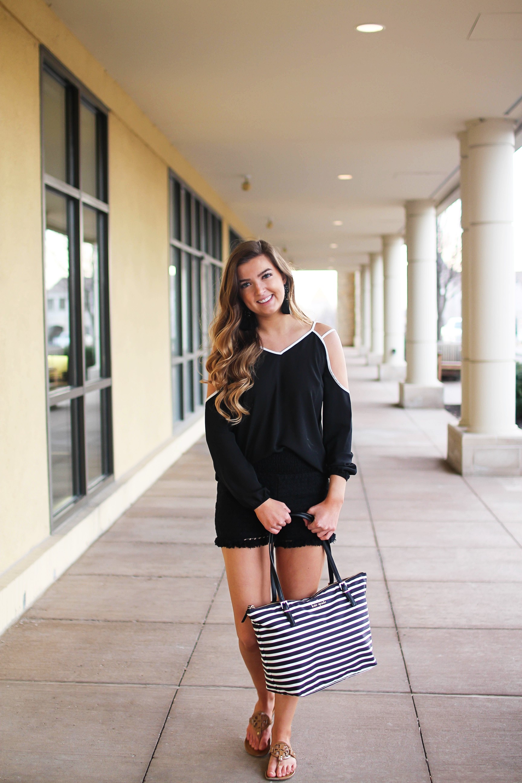 Black and white outfit! I love this black cold shoulder top with the white trim detail! I paired ti with some comfy black cotton shorts and my new black and white striped Kate spade tote! To finish off the outfit I put on my tassel earrings that are only $12! By Lauren Lindmark on Daily Dose of Charm dailydoseofcharm.com