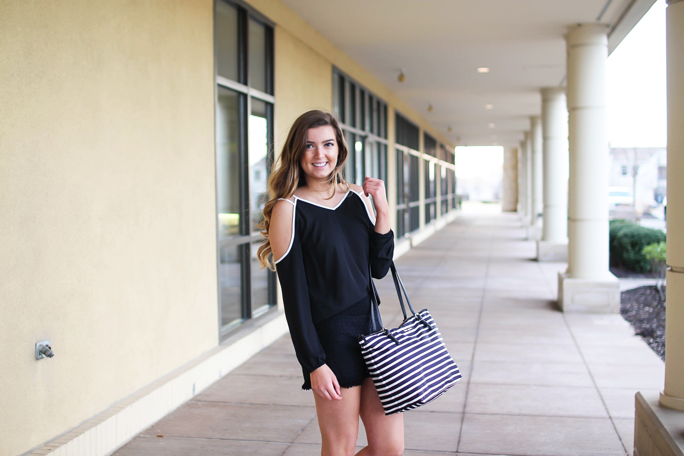 Black and white outfit! I love this black cold shoulder top with the white trim detail! I paired ti with some comfy black cotton shorts and my new black and white striped Kate spade tote! To finish off the outfit I put on my tassel earrings that are only $12! By Lauren Lindmark on Daily Dose of Charm dailydoseofcharm.com