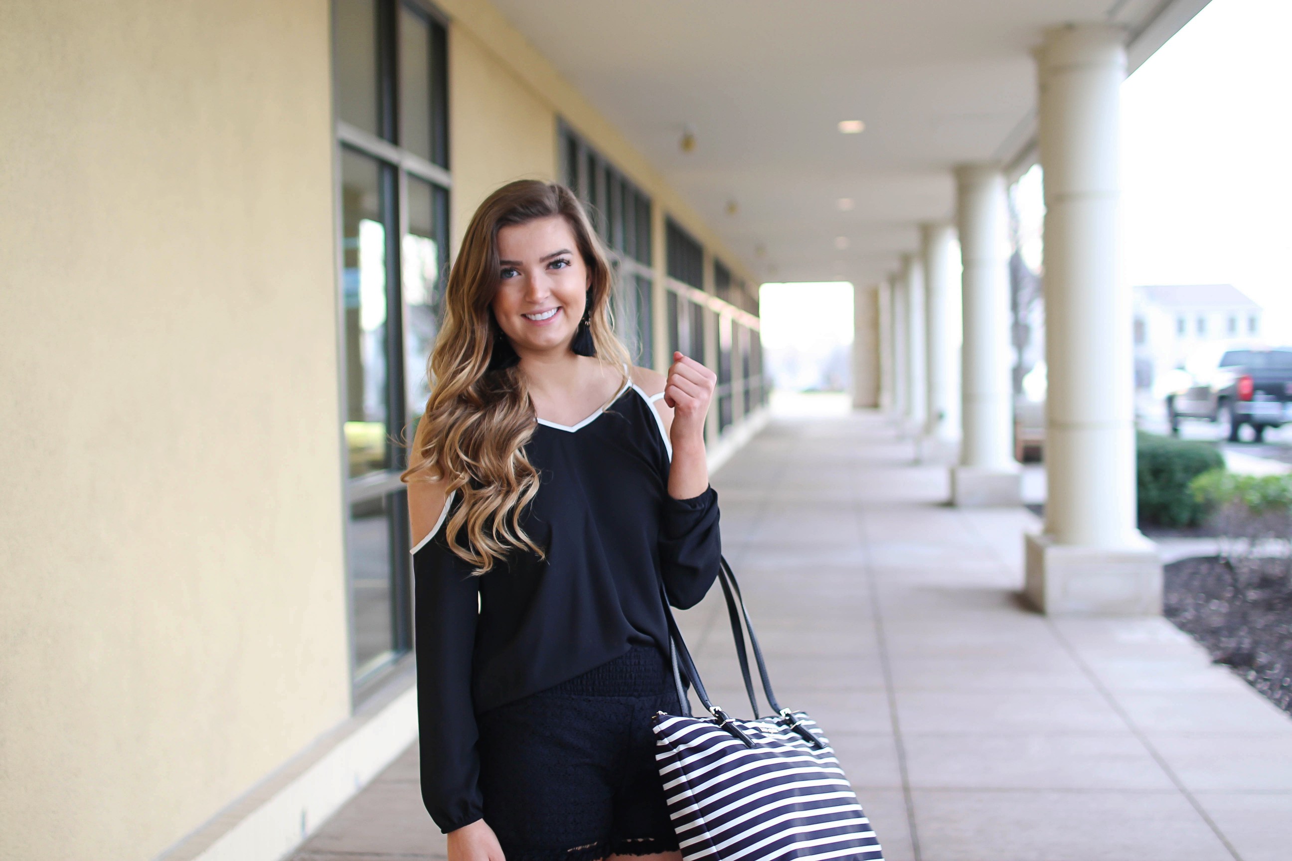 Black and white outfit! I love this black cold shoulder top with the white trim detail! I paired ti with some comfy black cotton shorts and my new black and white striped Kate spade tote! To finish off the outfit I put on my tassel earrings that are only $12! By Lauren Lindmark on Daily Dose of Charm dailydoseofcharm.com