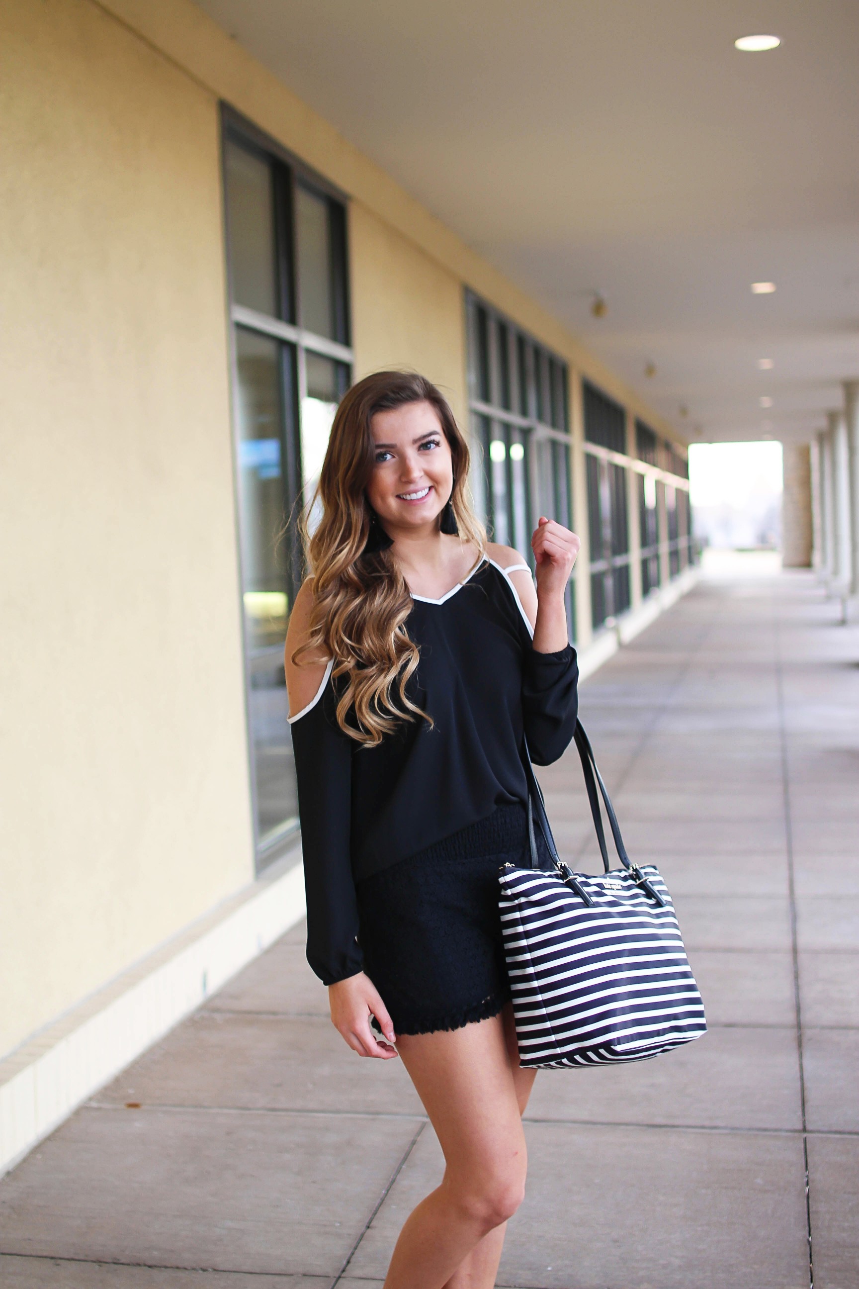 Black and white outfit! I love this black cold shoulder top with the white trim detail! I paired ti with some comfy black cotton shorts and my new black and white striped Kate spade tote! To finish off the outfit I put on my tassel earrings that are only $12! By Lauren Lindmark on Daily Dose of Charm dailydoseofcharm.com
