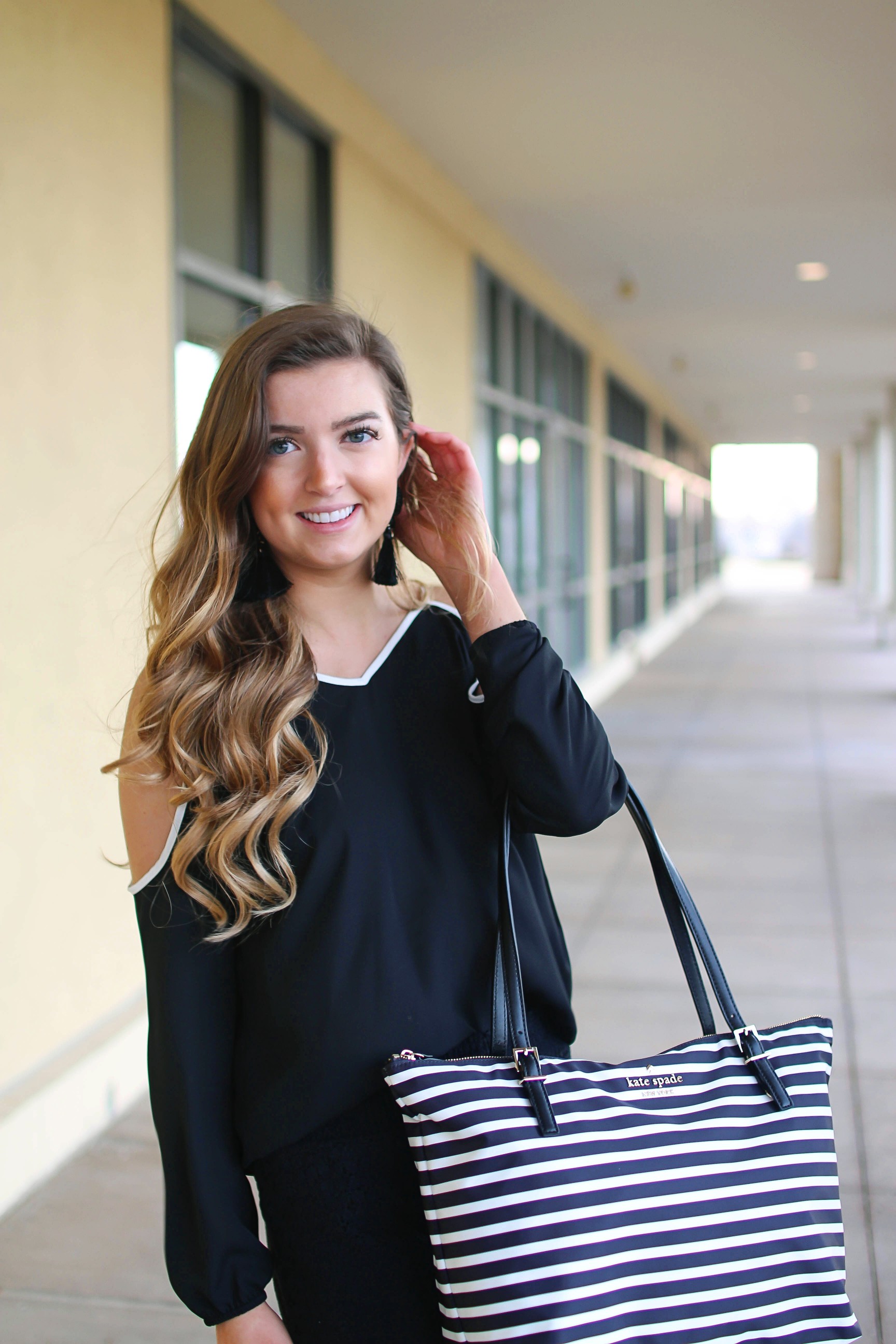 Black and white outfit! I love this black cold shoulder top with the white trim detail! I paired ti with some comfy black cotton shorts and my new black and white striped Kate spade tote! To finish off the outfit I put on my tassel earrings that are only $12! By Lauren Lindmark on Daily Dose of Charm dailydoseofcharm.com