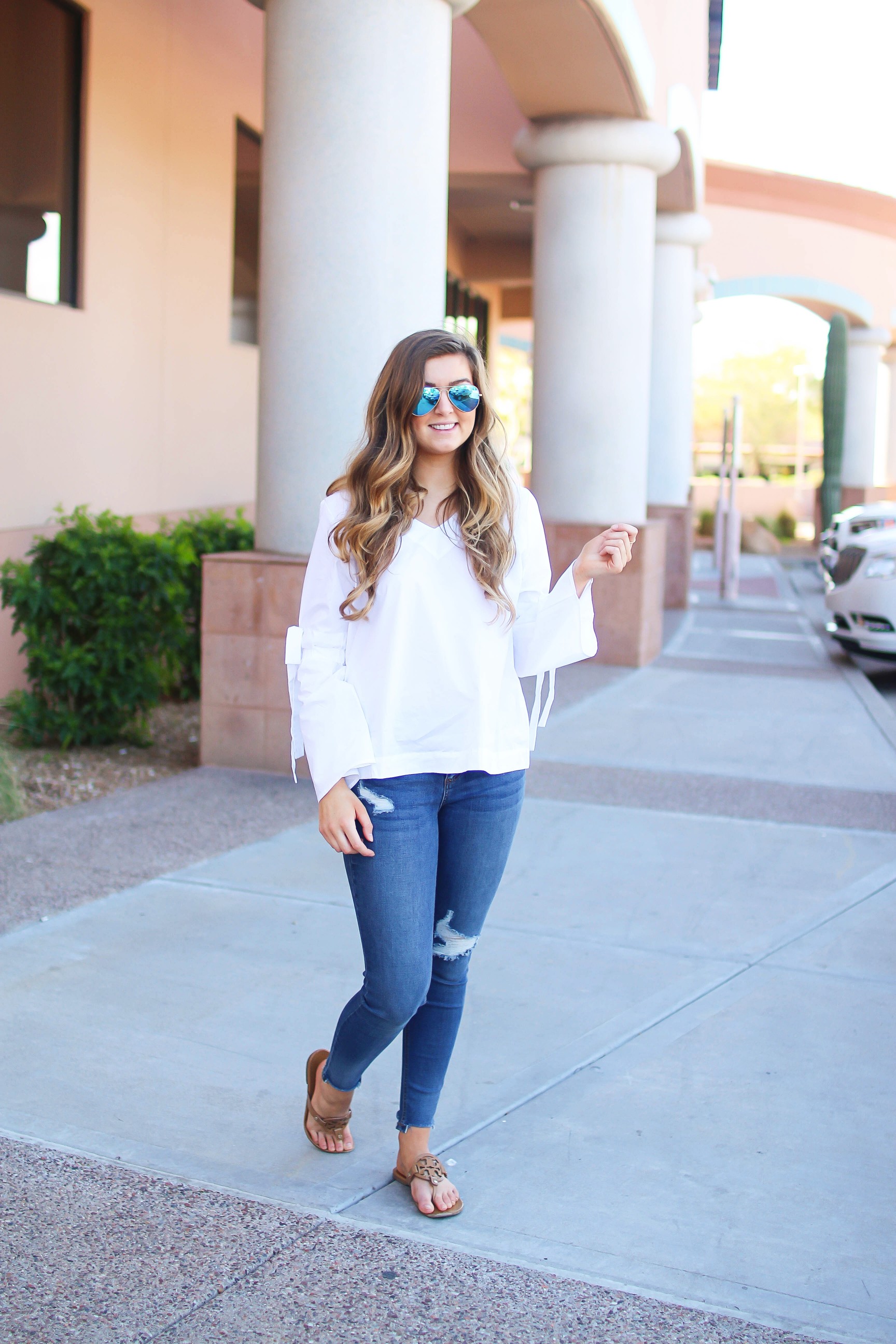 Love this white bow sleeve top that's only $28! It's so cute and classy, plus can be worn with so many things! I paired this top with my favorite ripped jeans, tory burch miller, and blue mirrored ray ban aviators! By Lauren Lindmark on dailydoseofcharm.com daily dose of charm