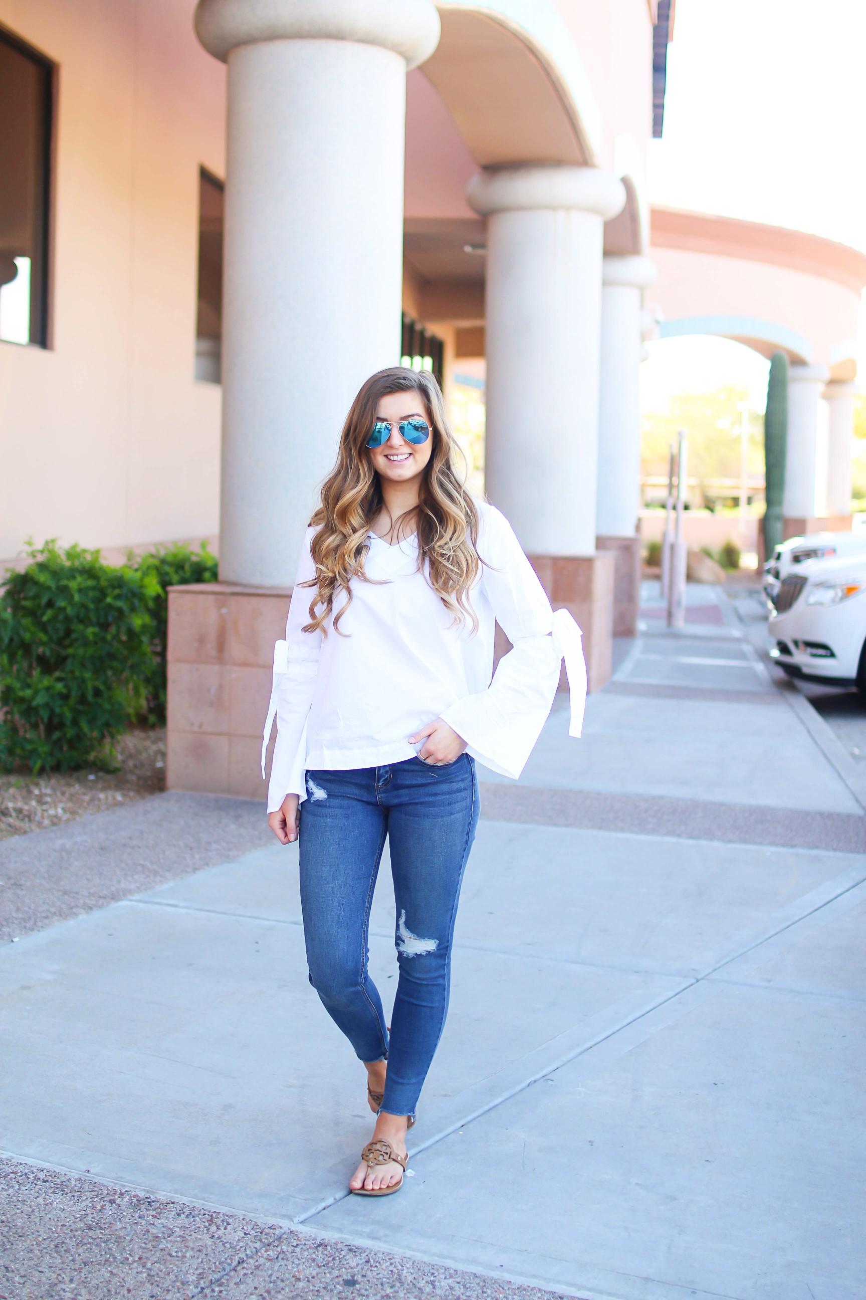 Love this white bow sleeve top that's only $28! It's so cute and classy, plus can be worn with so many things! I paired this top with my favorite ripped jeans, tory burch miller, and blue mirrored ray ban aviators! By Lauren Lindmark on dailydoseofcharm.com daily dose of charm