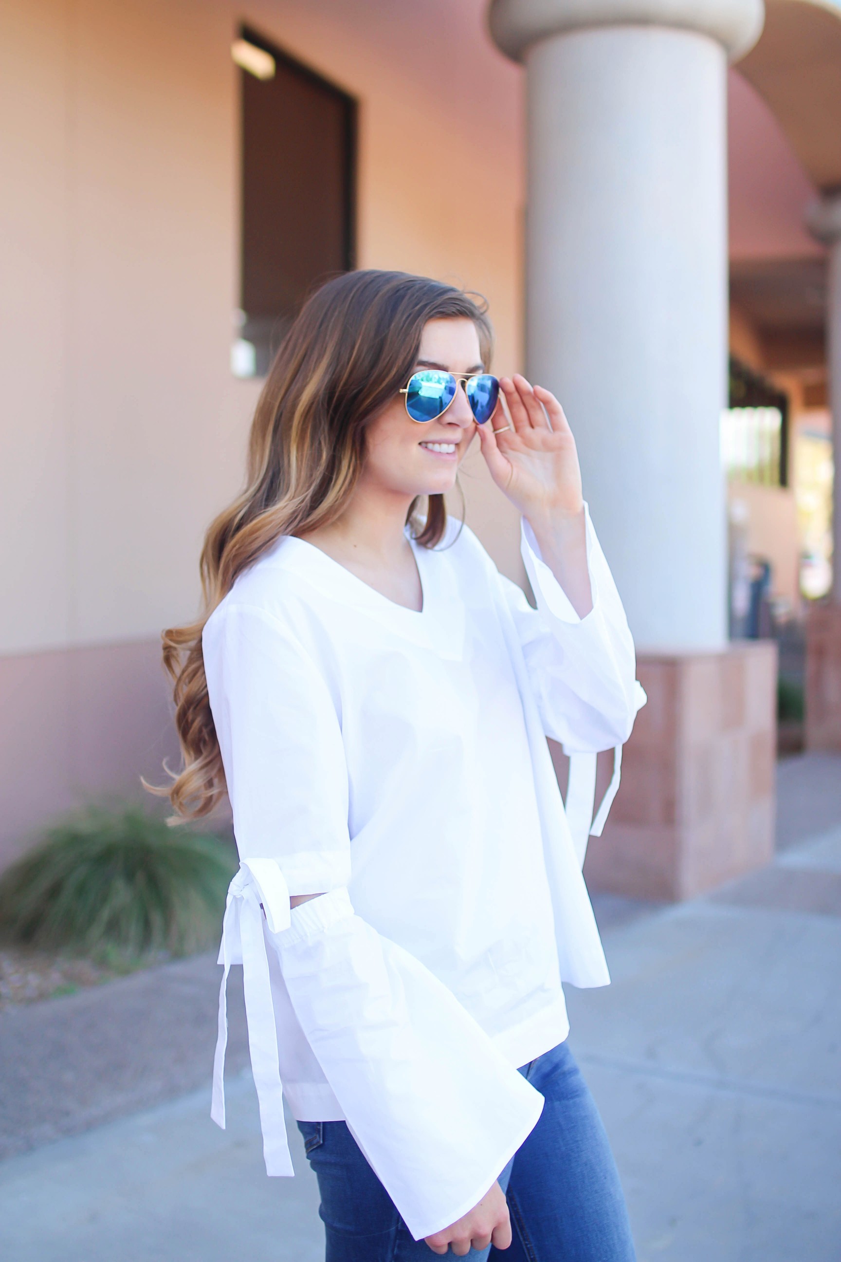 Love this white bow sleeve top that's only $28! It's so cute and classy, plus can be worn with so many things! I paired this top with my favorite ripped jeans, tory burch miller, and blue mirrored ray ban aviators! By Lauren Lindmark on dailydoseofcharm.com daily dose of charm