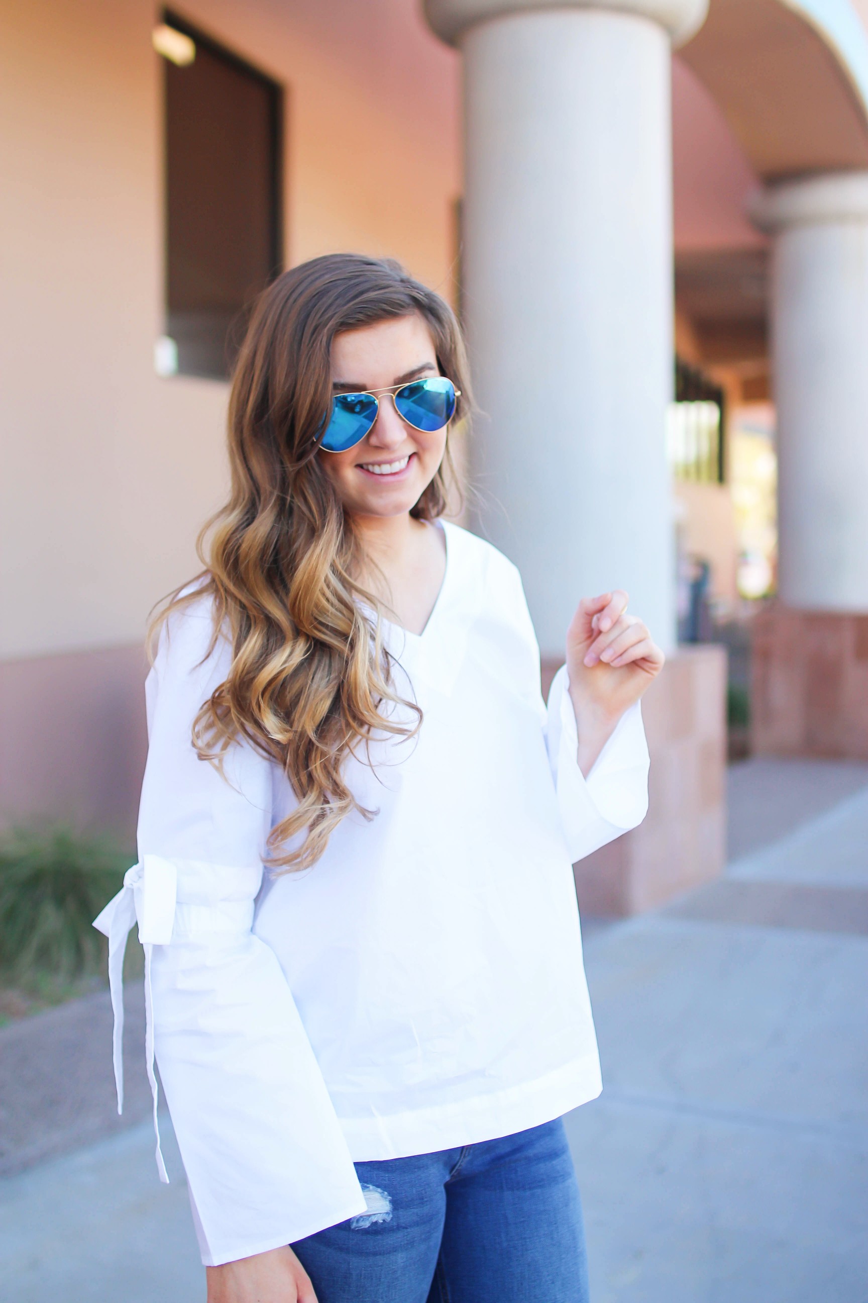 Love this white bow sleeve top that's only $28! It's so cute and classy, plus can be worn with so many things! I paired this top with my favorite ripped jeans, tory burch miller, and blue mirrored ray ban aviators! By Lauren Lindmark on dailydoseofcharm.com daily dose of charm