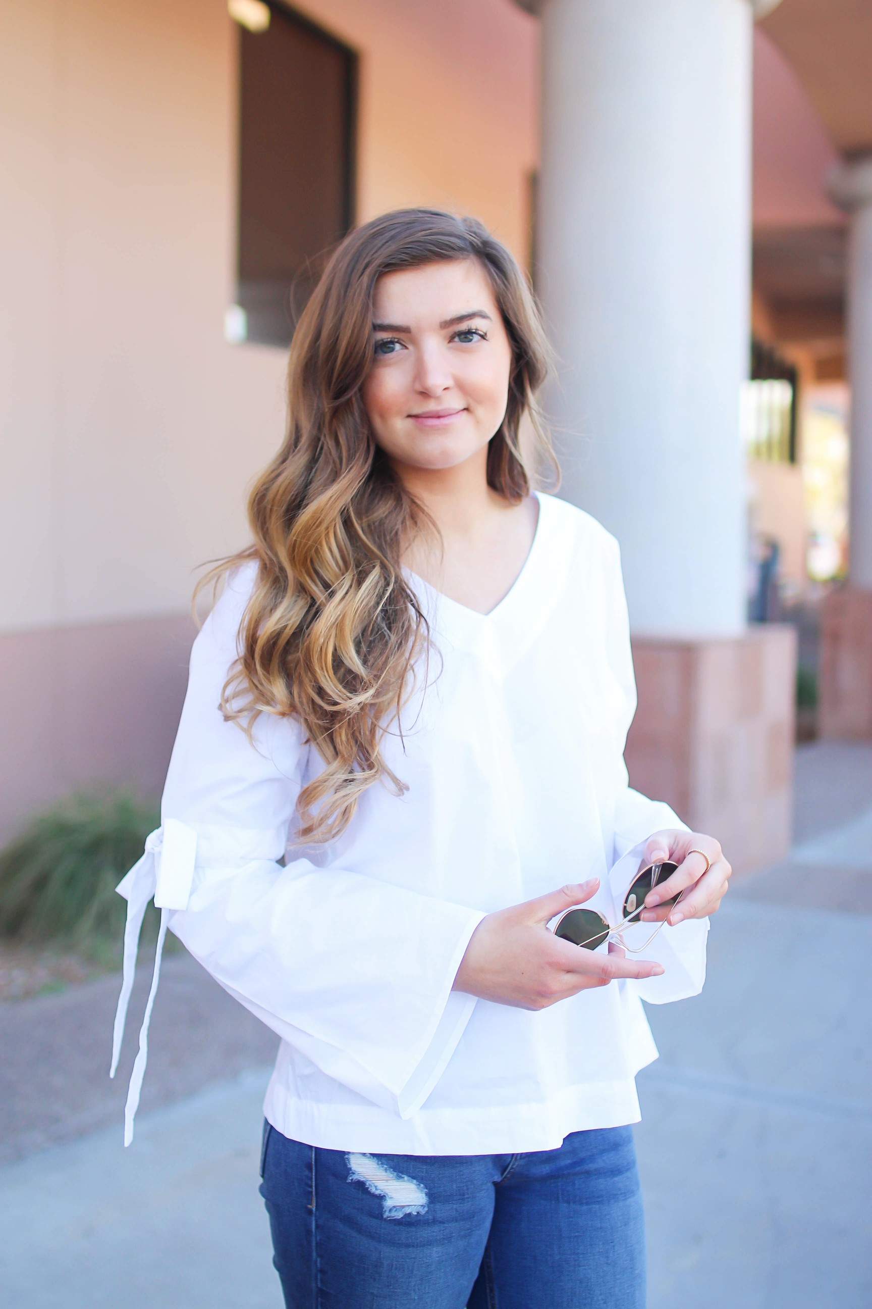 Love this white bow sleeve top that's only $28! It's so cute and classy, plus can be worn with so many things! I paired this top with my favorite ripped jeans, tory burch miller, and blue mirrored ray ban aviators! By Lauren Lindmark on dailydoseofcharm.com daily dose of charm