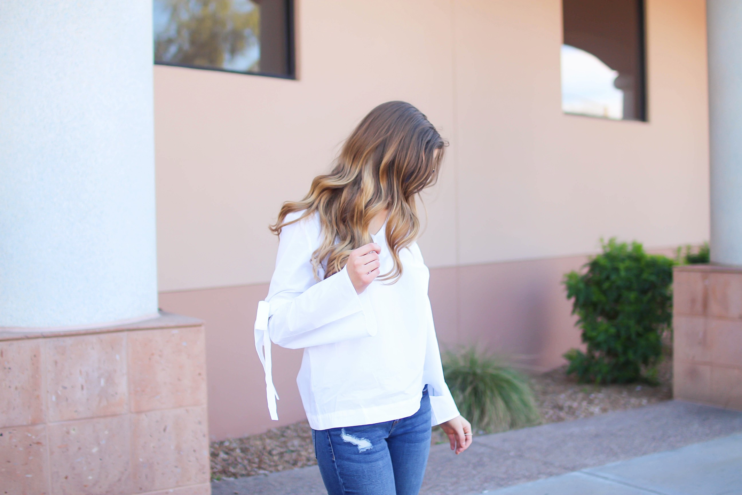 Love this white bow sleeve top that's only $28! It's so cute and classy, plus can be worn with so many things! I paired this top with my favorite ripped jeans, tory burch miller, and blue mirrored ray ban aviators! By Lauren Lindmark on dailydoseofcharm.com daily dose of charm