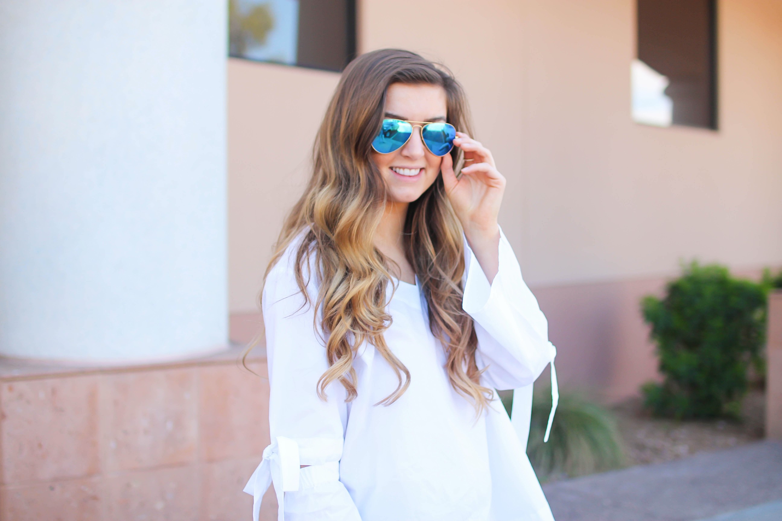 Love this white bow sleeve top that's only $28! It's so cute and classy, plus can be worn with so many things! I paired this top with my favorite ripped jeans, tory burch miller, and blue mirrored ray ban aviators! By Lauren Lindmark on dailydoseofcharm.com daily dose of charm