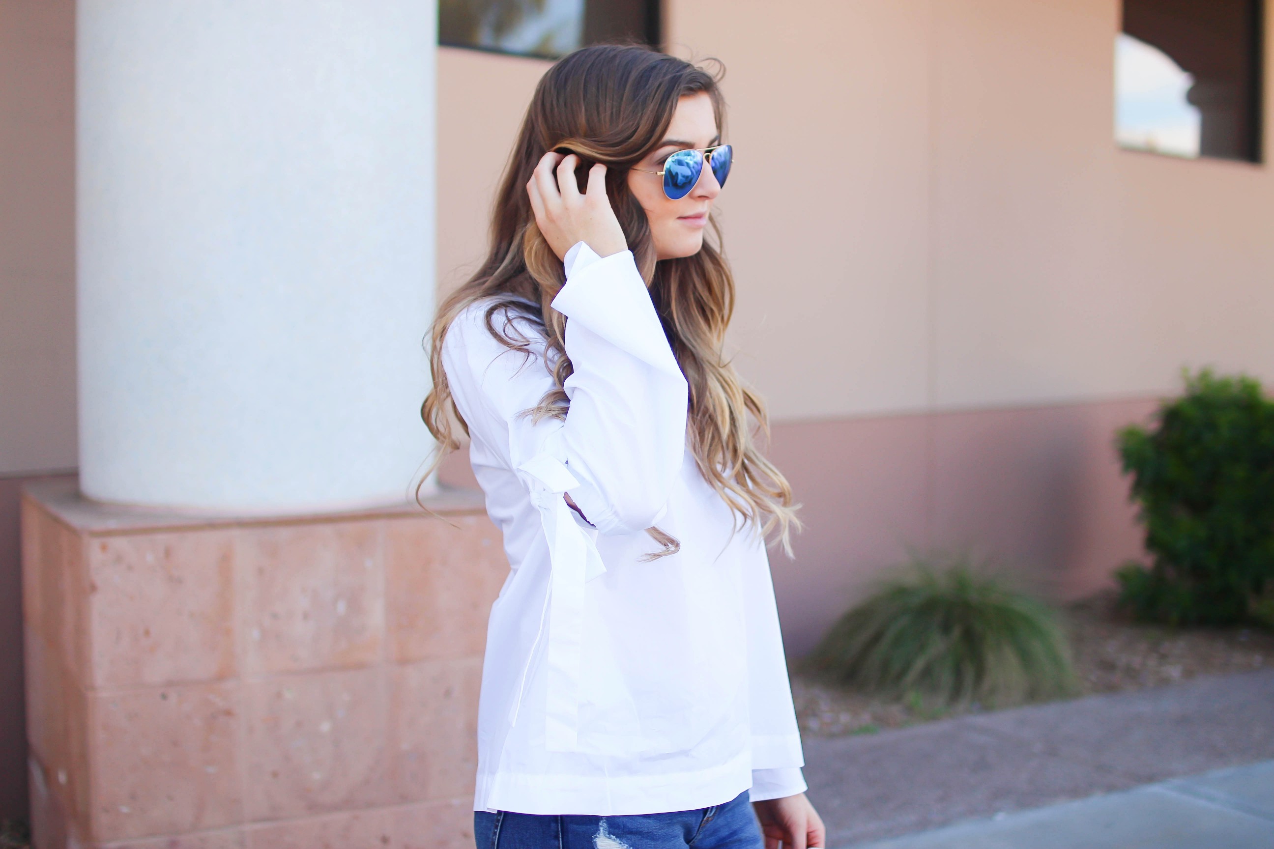 Love this white bow sleeve top that's only $28! It's so cute and classy, plus can be worn with so many things! I paired this top with my favorite ripped jeans, tory burch miller, and blue mirrored ray ban aviators! By Lauren Lindmark on dailydoseofcharm.com daily dose of charm