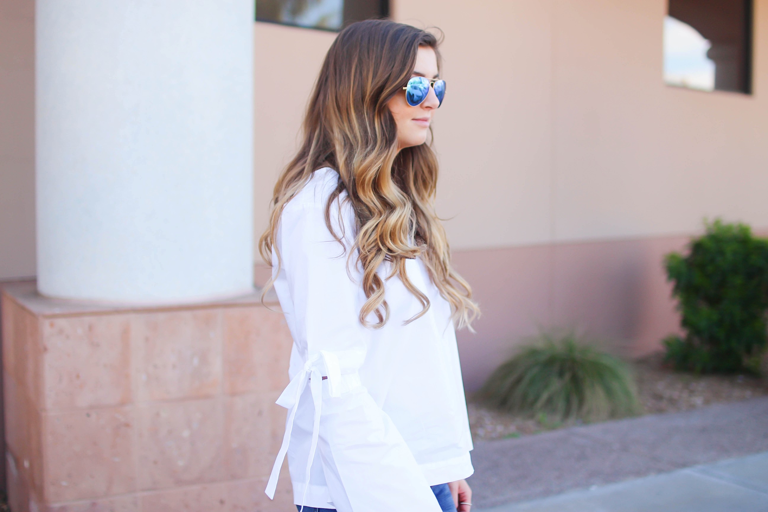 Love this white bow sleeve top that's only $28! It's so cute and classy, plus can be worn with so many things! I paired this top with my favorite ripped jeans, tory burch miller, and blue mirrored ray ban aviators! By Lauren Lindmark on dailydoseofcharm.com daily dose of charm