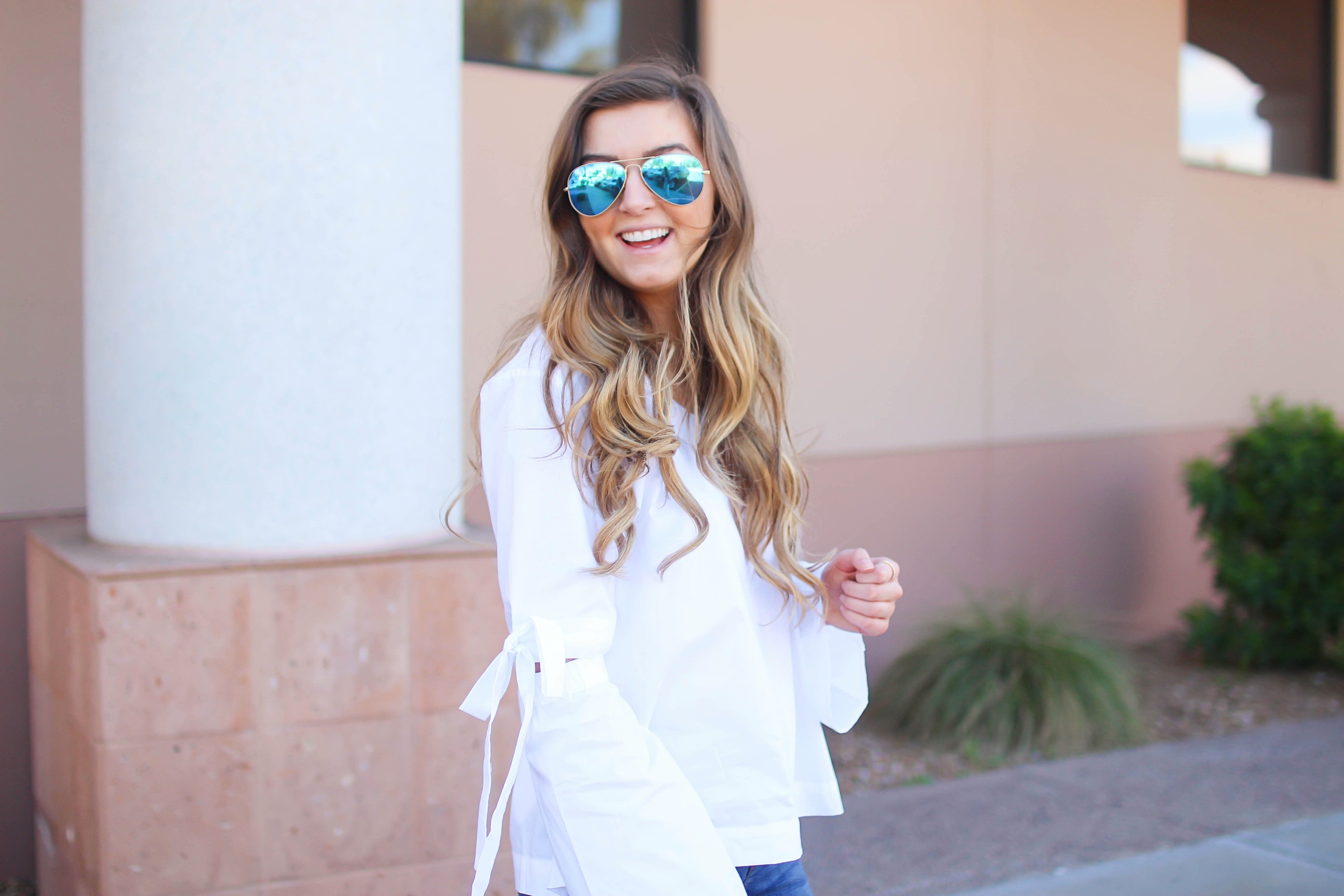 Love this white bow sleeve top that's only $28! It's so cute and classy, plus can be worn with so many things! I paired this top with my favorite ripped jeans, tory burch miller, and blue mirrored ray ban aviators! By Lauren Lindmark on dailydoseofcharm.com daily dose of charm