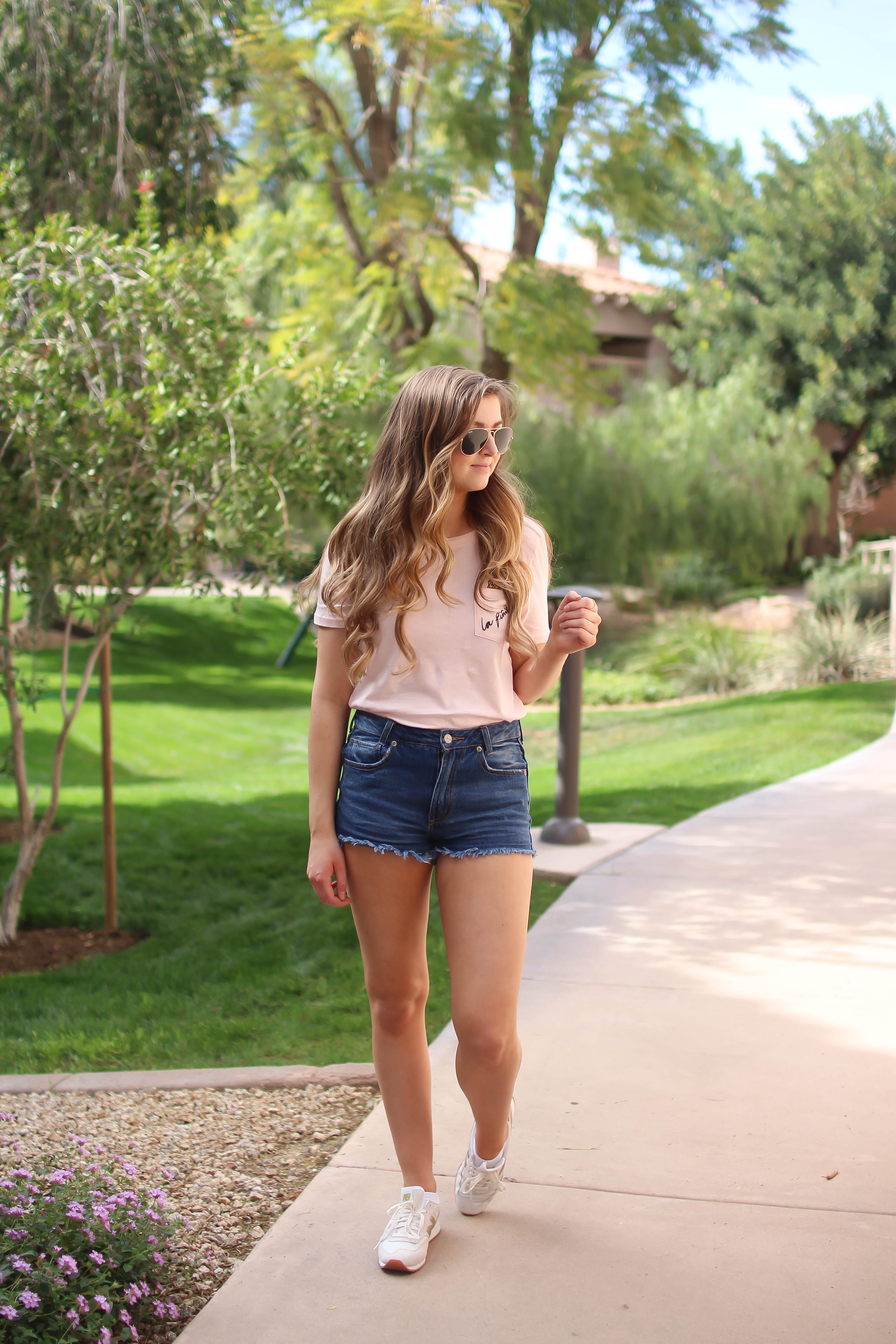 The cutest pink pineapple tee perfect for spring break and summer look! Perfect outfit idea for spring and summer! Paired with jean shorts and Gold New Balance shoes. By Lauren Lindmark on Daily Dose of Charm dailydoseofcharm.com