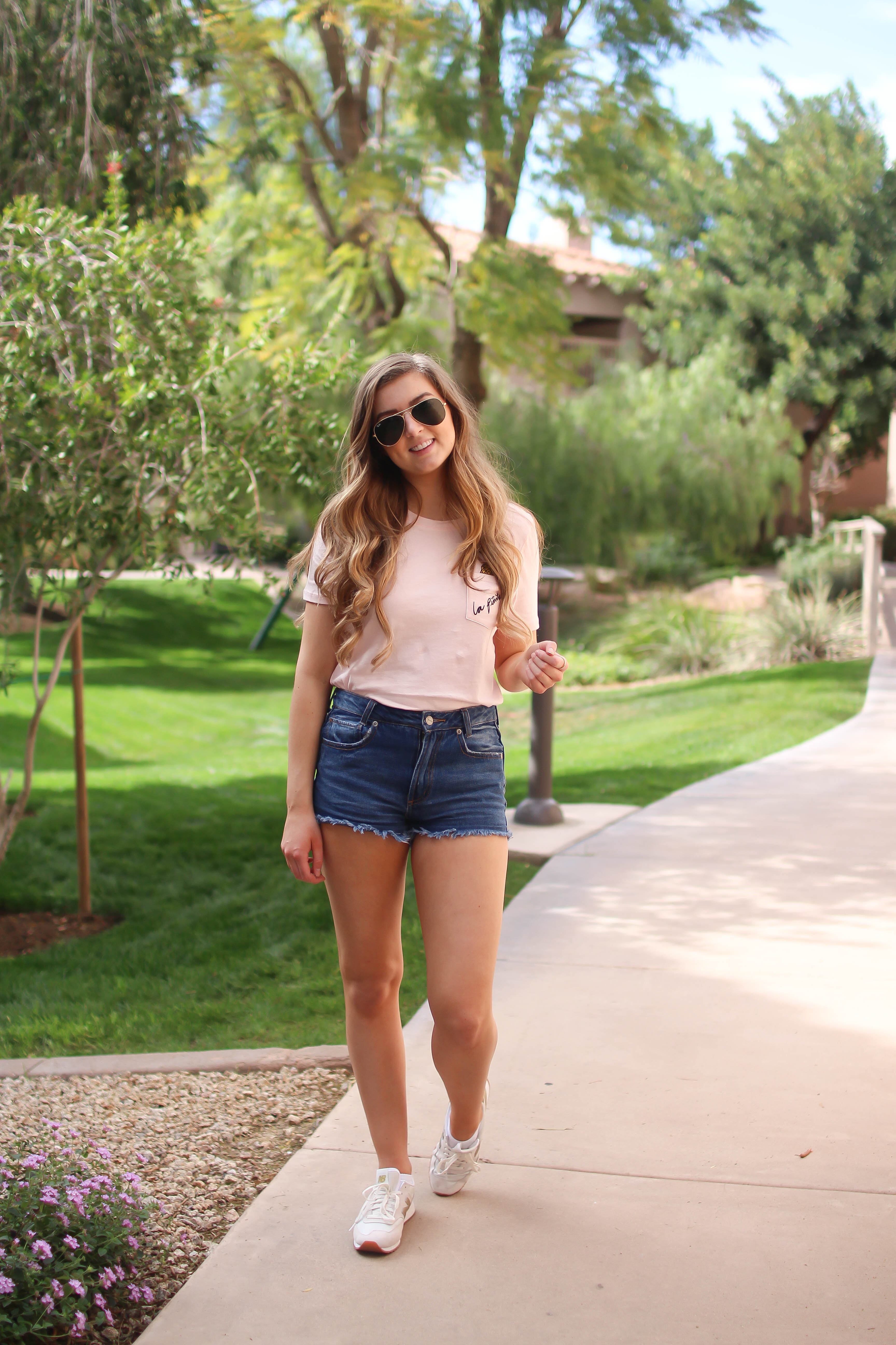 The cutest pink pineapple tee perfect for spring break and summer look! Perfect outfit idea for spring and summer! Paired with jean shorts and Gold New Balance shoes. By Lauren Lindmark on Daily Dose of Charm dailydoseofcharm.com