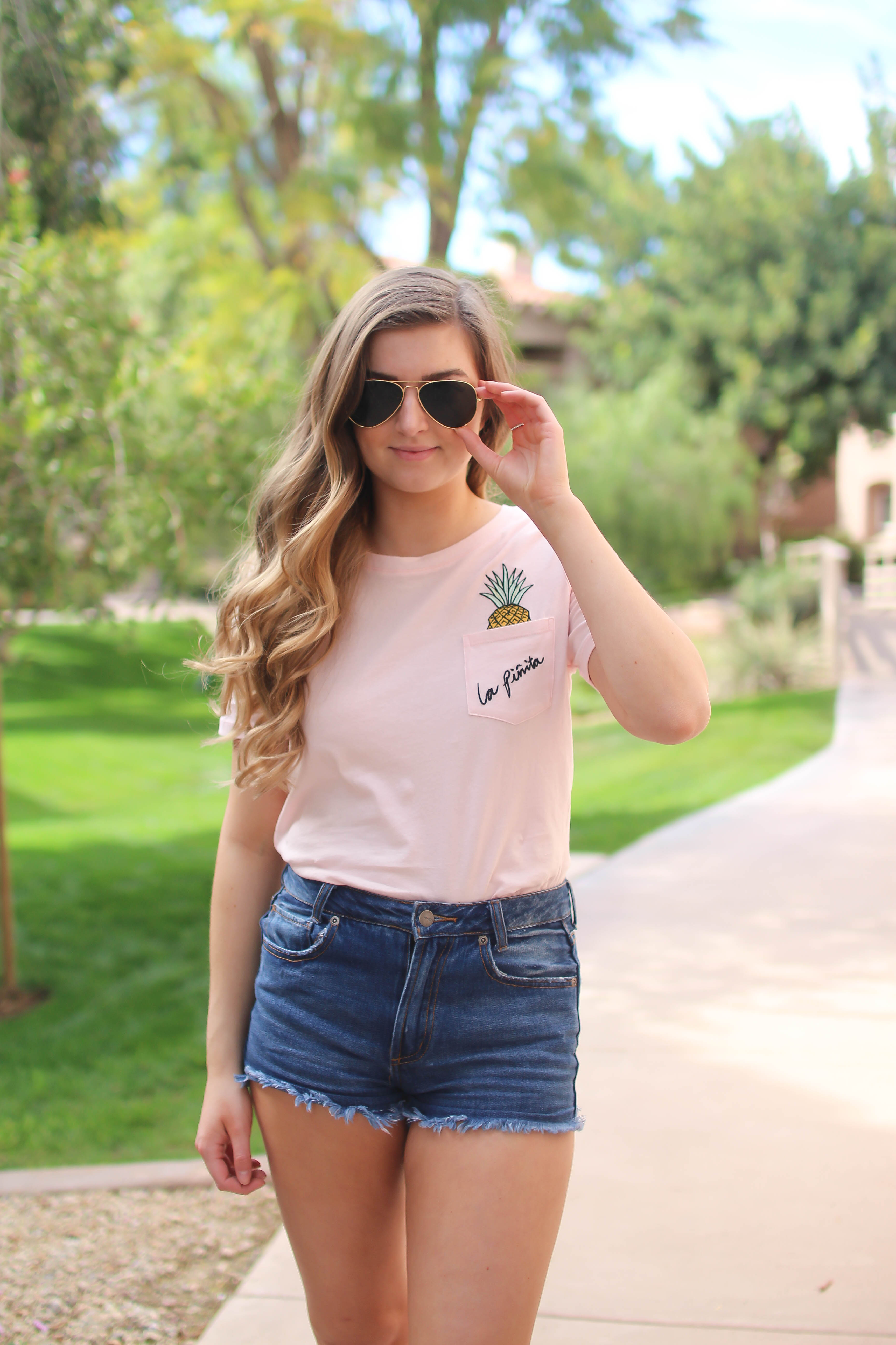 The cutest pink pineapple tee perfect for spring break and summer look! Perfect outfit idea for spring and summer! Paired with jean shorts and Gold New Balance shoes. By Lauren Lindmark on Daily Dose of Charm dailydoseofcharm.com