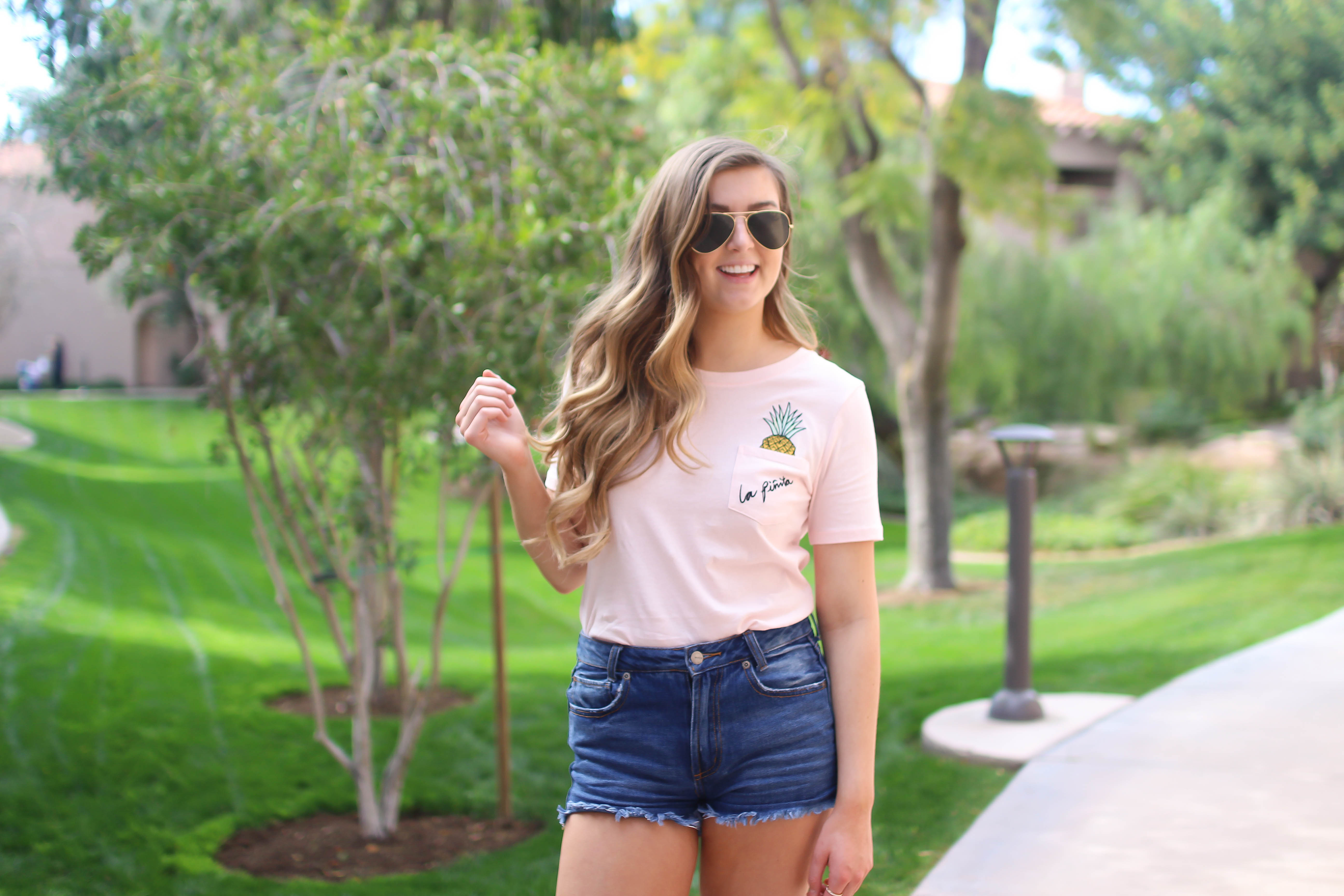 The cutest pink pineapple tee perfect for spring break and summer look! Perfect outfit idea for spring and summer! Paired with jean shorts and Gold New Balance shoes. By Lauren Lindmark on Daily Dose of Charm dailydoseofcharm.com