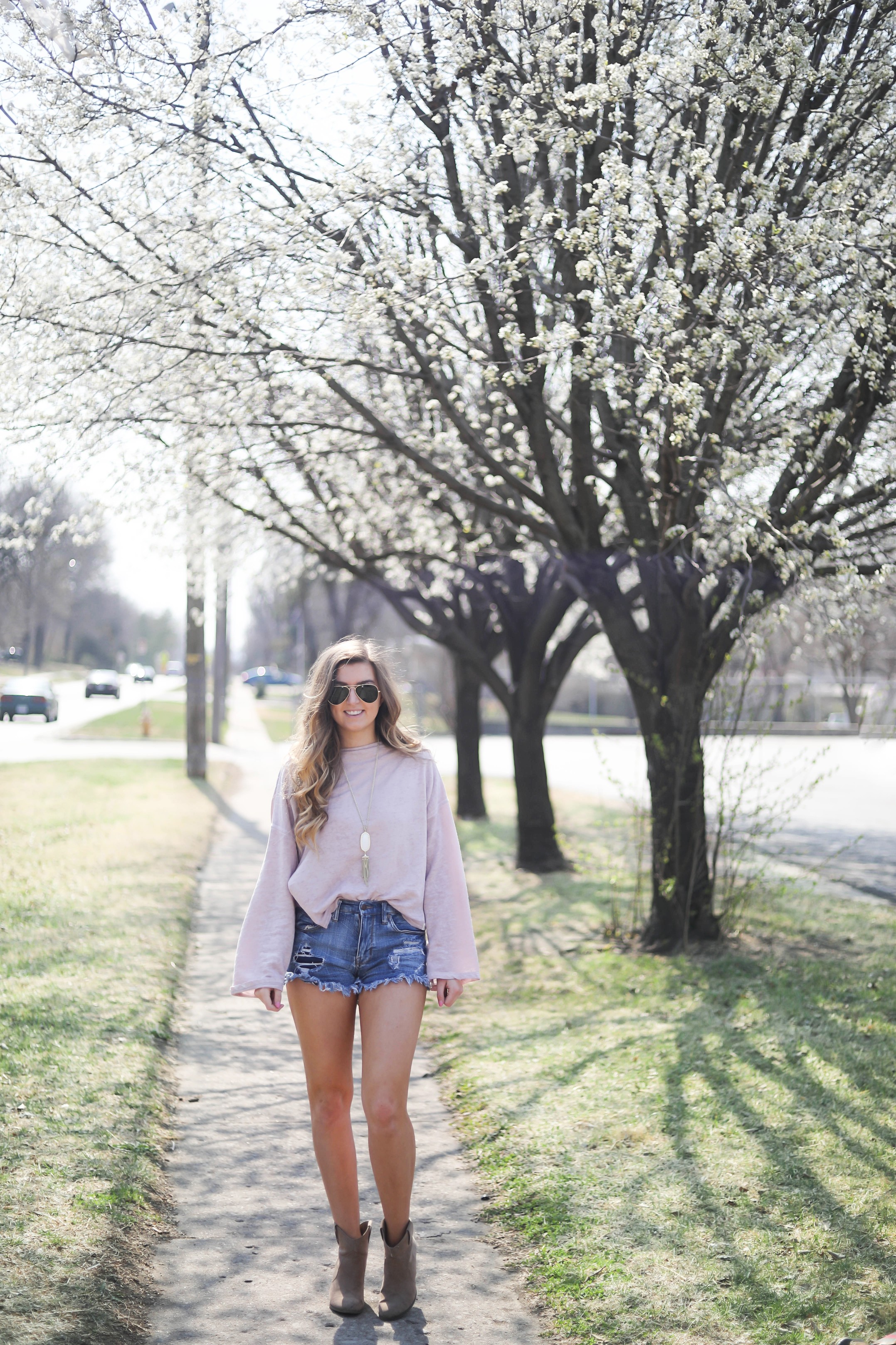 Spring outfit! You can tell it's officially spring when the trees start to bloom! I love this cozy pink top with ripped jeans. I paired them with my favorite booties and white kendra Scott necklace! By Lauren Lindmark dailydoseofcharm.com daily dose of charm