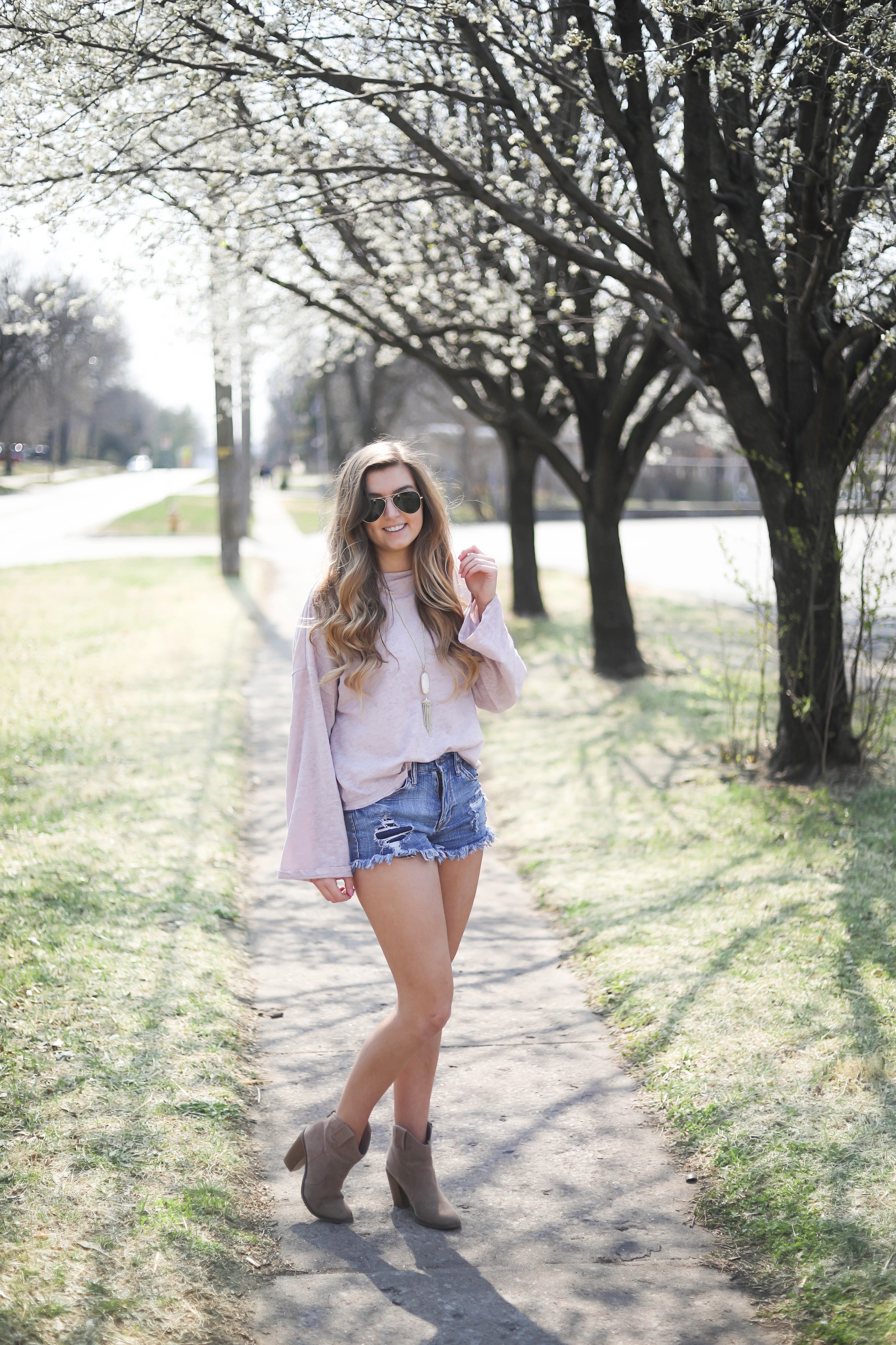 Spring outfit! You can tell it's officially spring when the trees start to bloom! I love this cozy pink top with ripped jeans. I paired them with my favorite booties and white kendra Scott necklace! By Lauren Lindmark dailydoseofcharm.com daily dose of charm