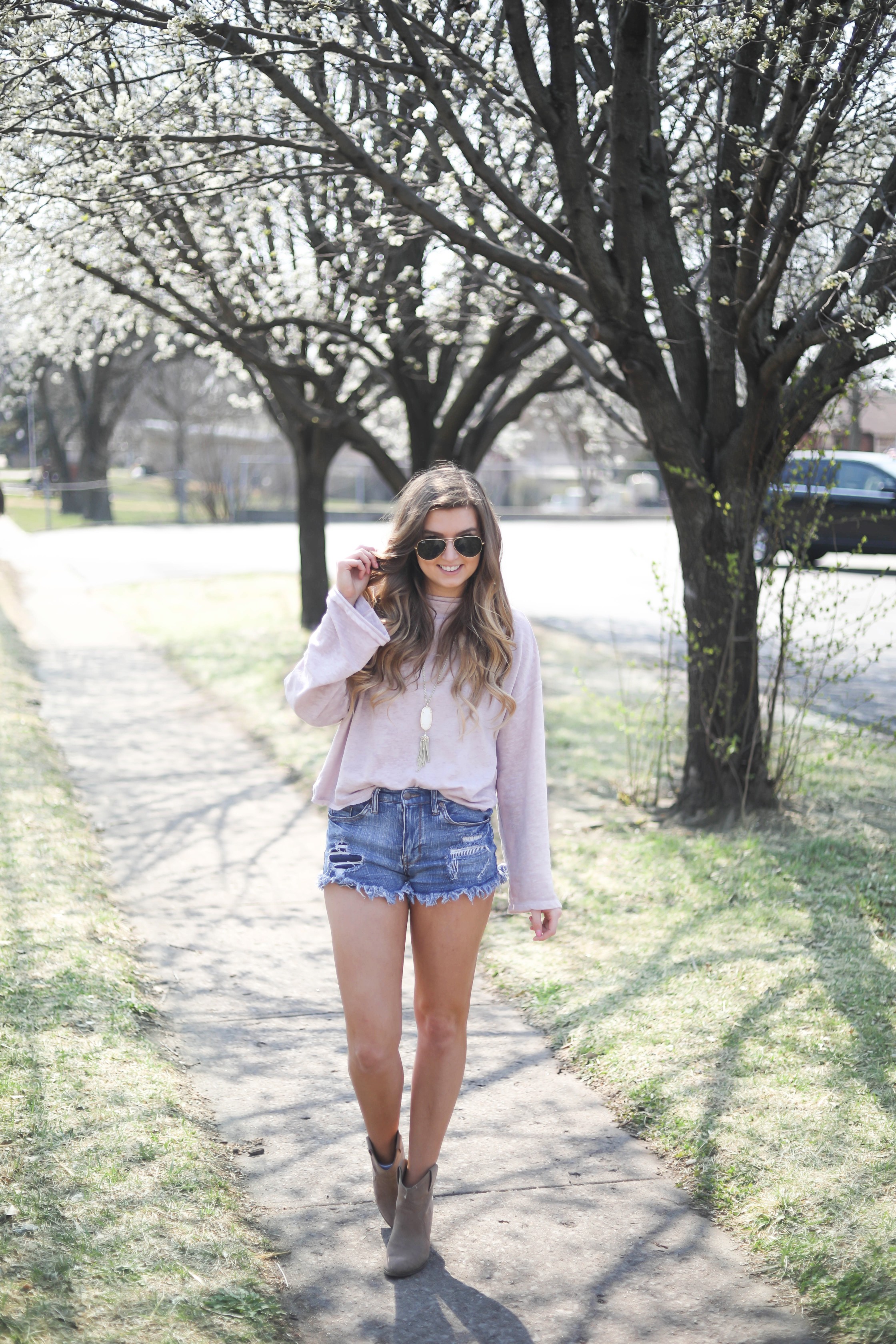 Spring outfit! You can tell it's officially spring when the trees start to bloom! I love this cozy pink top with ripped jeans. I paired them with my favorite booties and white kendra Scott necklace! By Lauren Lindmark dailydoseofcharm.com daily dose of charm