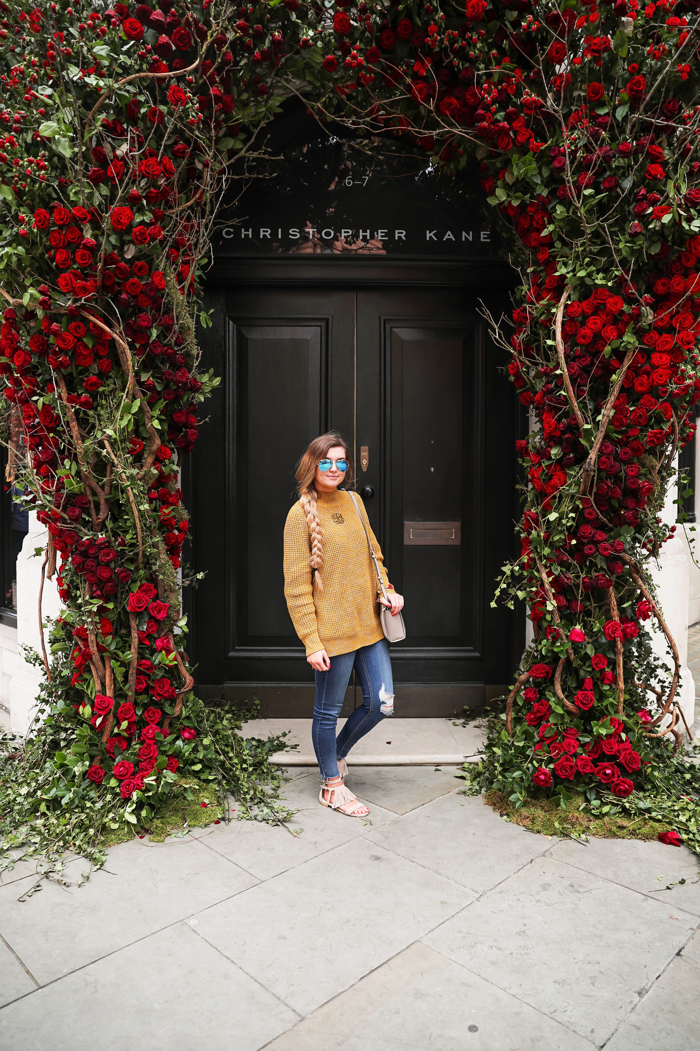 The cutest yellow sweater up on the blog! These photos were taken in front of the most beautiful roses in London! Cute London outfit! By Lauren Lindmark on dailydoseofcharm.com daily dose of charm