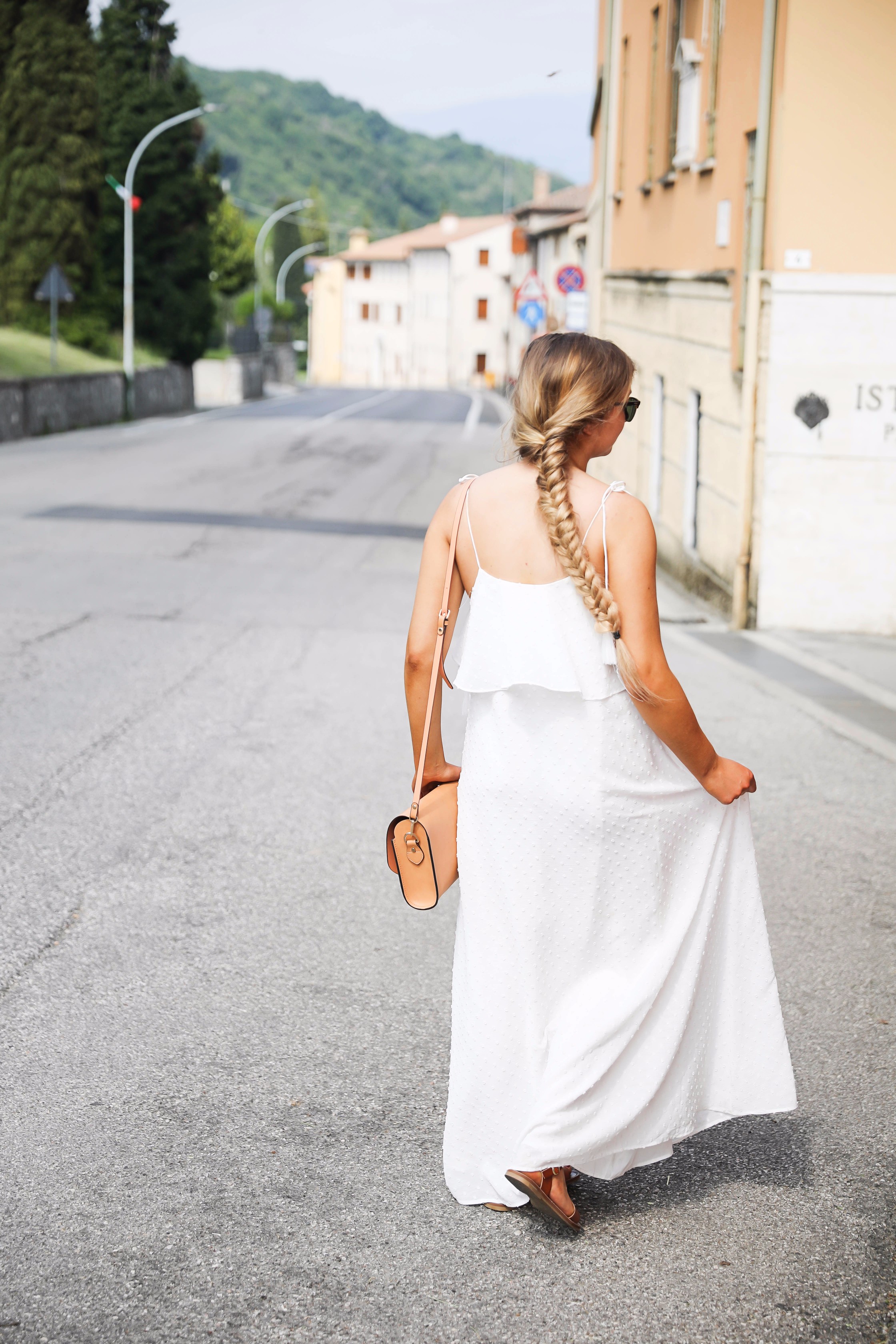 White flowy maxi dress with long fishtail braid in Paderno del Grappa, Italy by fashion blogger Lauren Lindmark daily dose of charm dailydoseofcharm.com