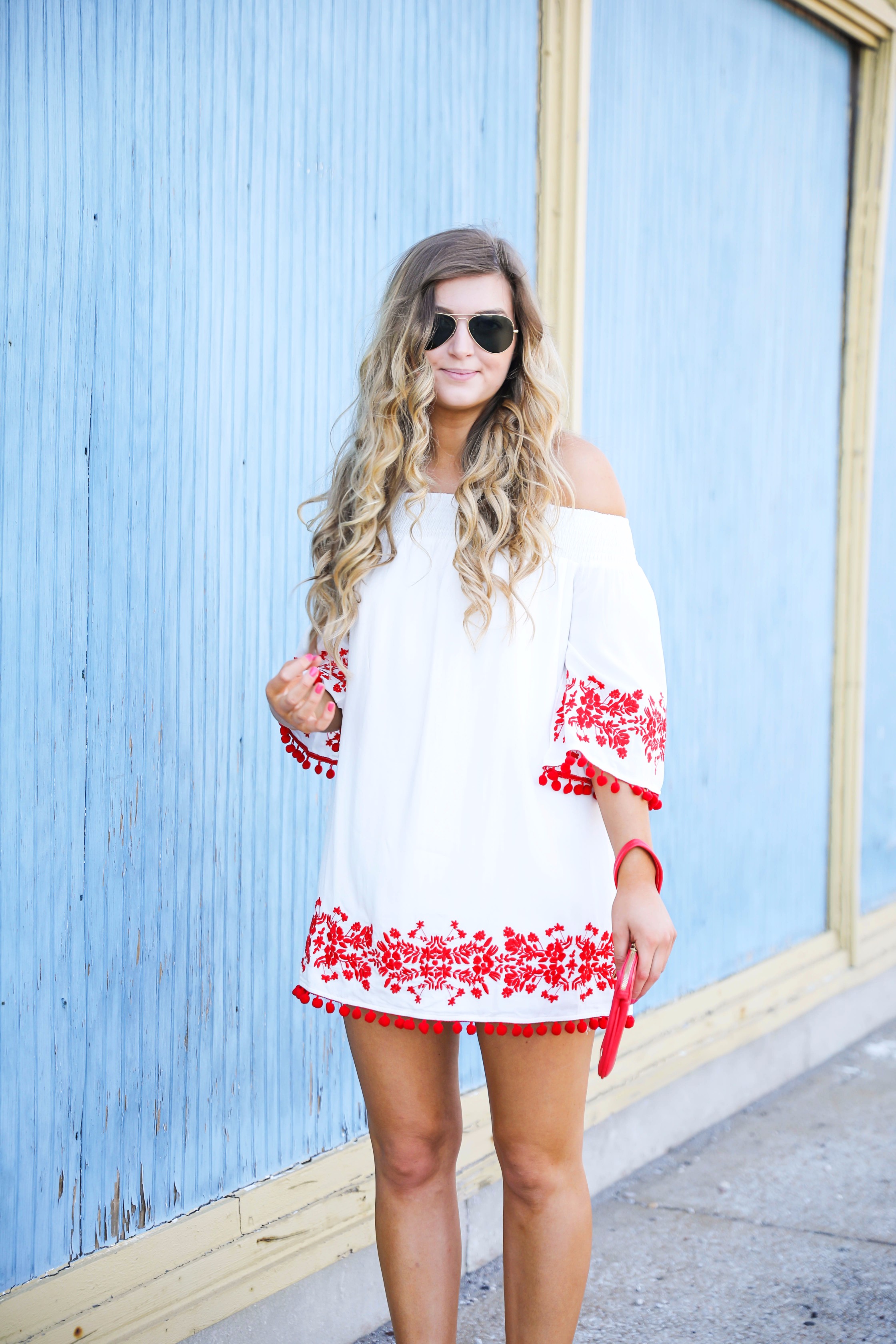 Looking for the perfect fourth of july or summer outfit? This red pom pom off the shoulder dress is so cute with it's embroidered hem! I wore this on the fourth of july! Featured on fashion blog daily dose of charm by lauren lindmark