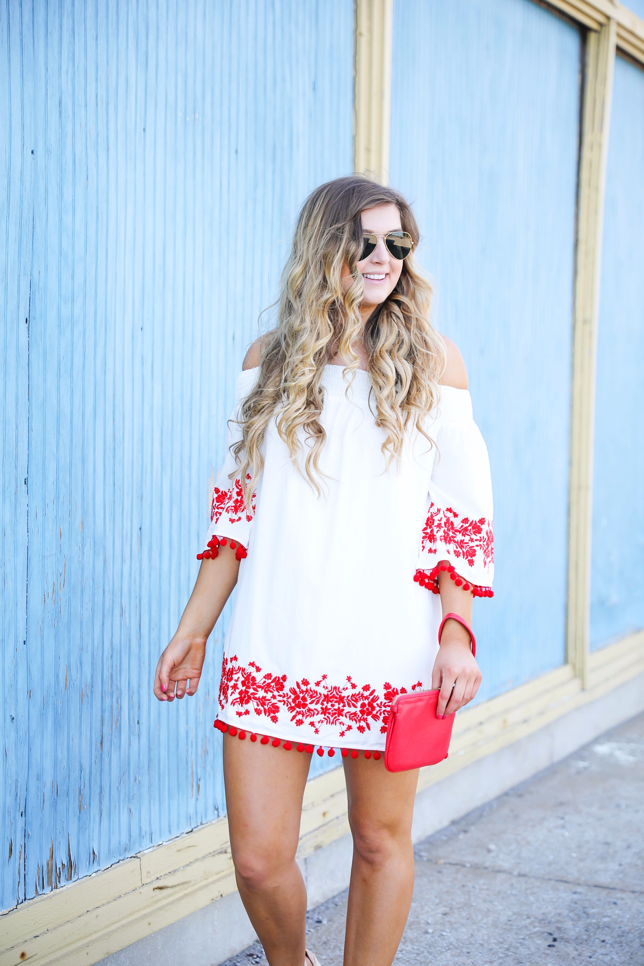 Looking for the perfect fourth of july or summer outfit? This red pom pom off the shoulder dress is so cute with it's embroidered hem! I wore this on the fourth of july! Featured on fashion blog daily dose of charm by lauren lindmark